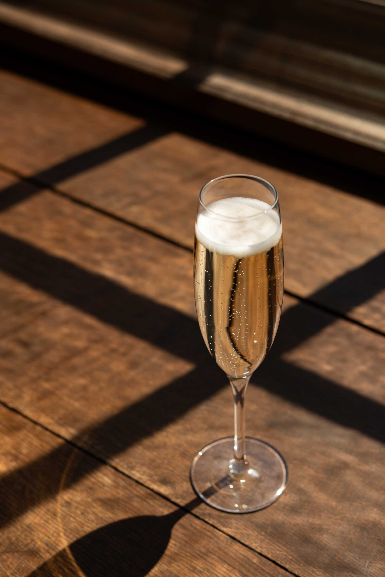 zonlicht die binnenvalt door de ramen van een restaurant op een glas champagne