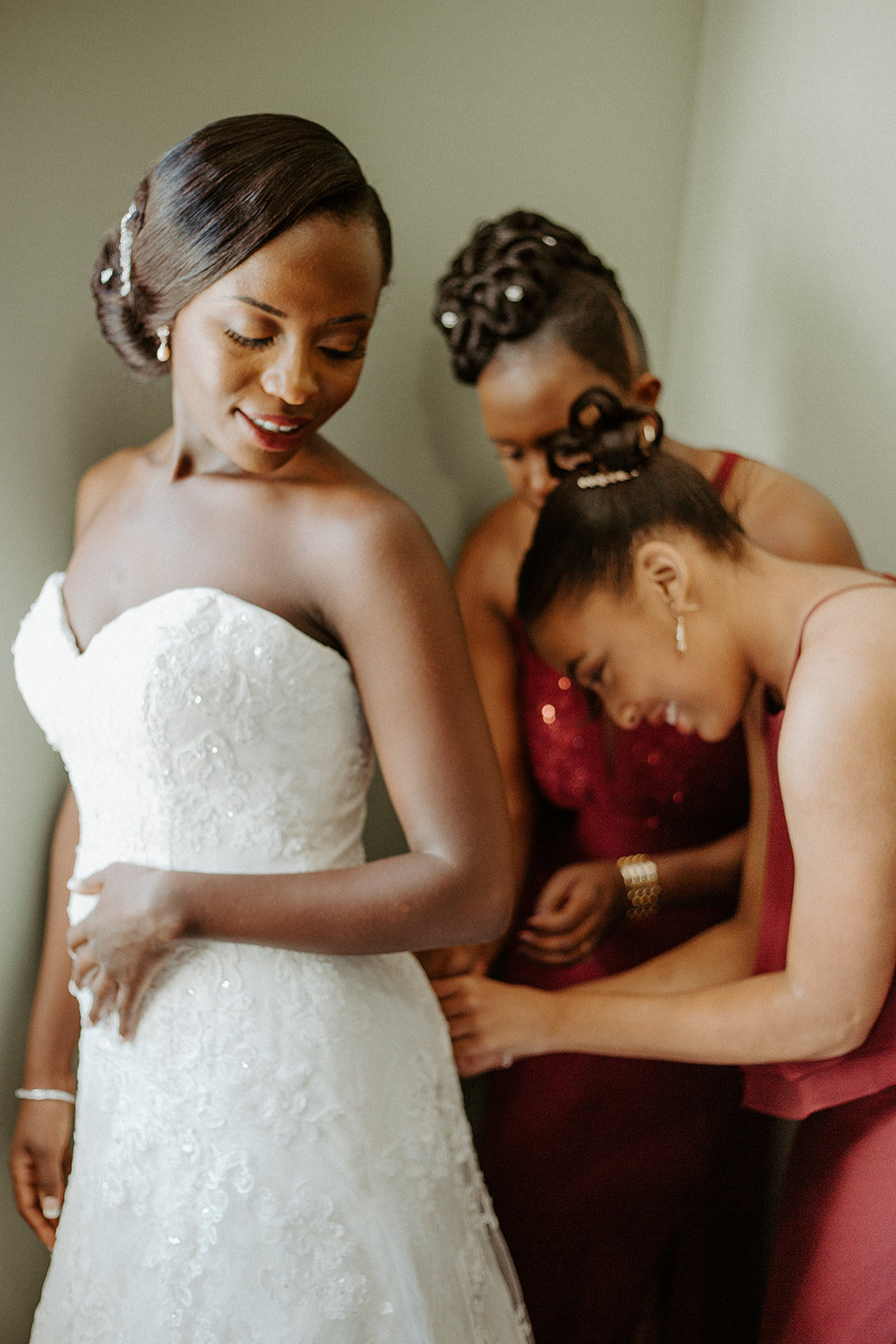 Bridesmaids helping the bride get her wedding dress on during his Minneapolis wedding