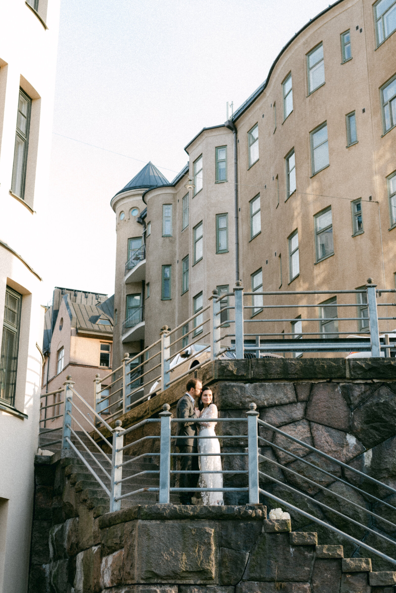 Wedding couple standing on the stairs in the city.  Nordic elopement wedding photographer Hannika Gabrielsson photographed the couple in spring.