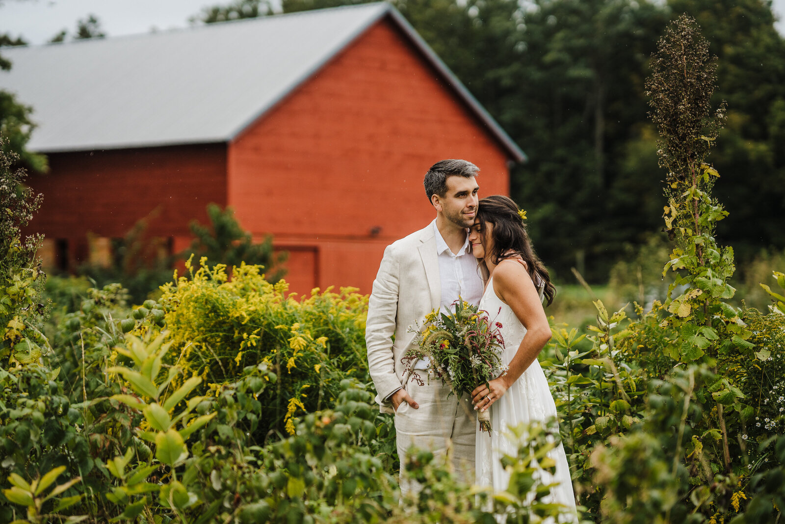 couple gets married in front of red barn on farm