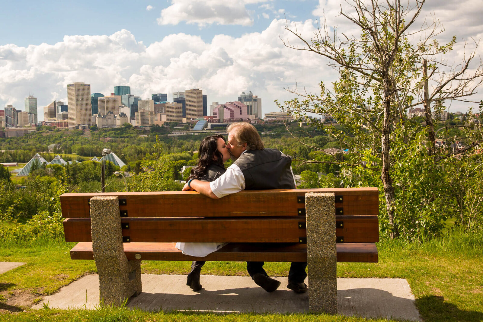 Engagement couple on bench overlooking downtown Edmonton