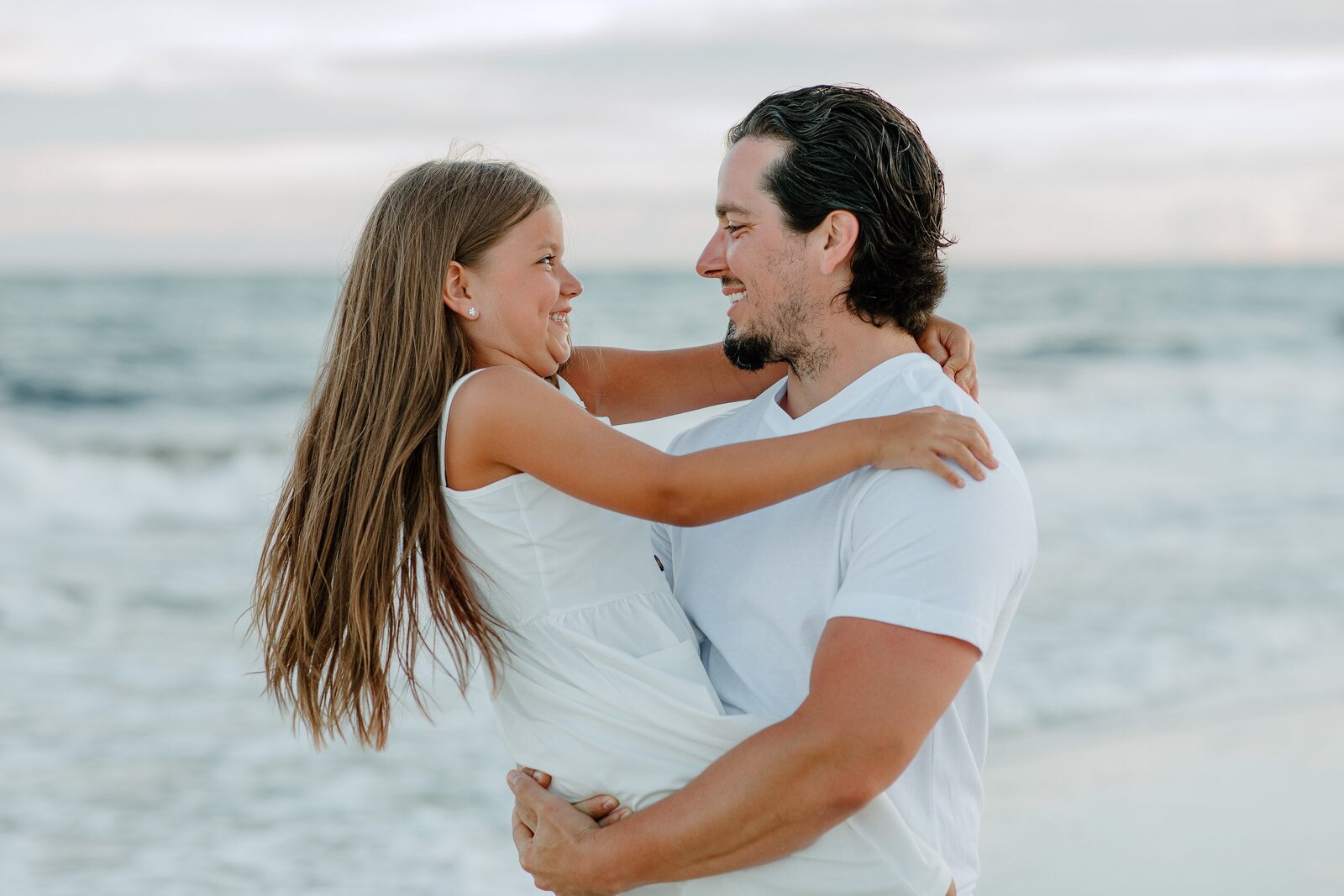 Pensacola Beach vacation family photography session .  Father and daughter playing on the beach.