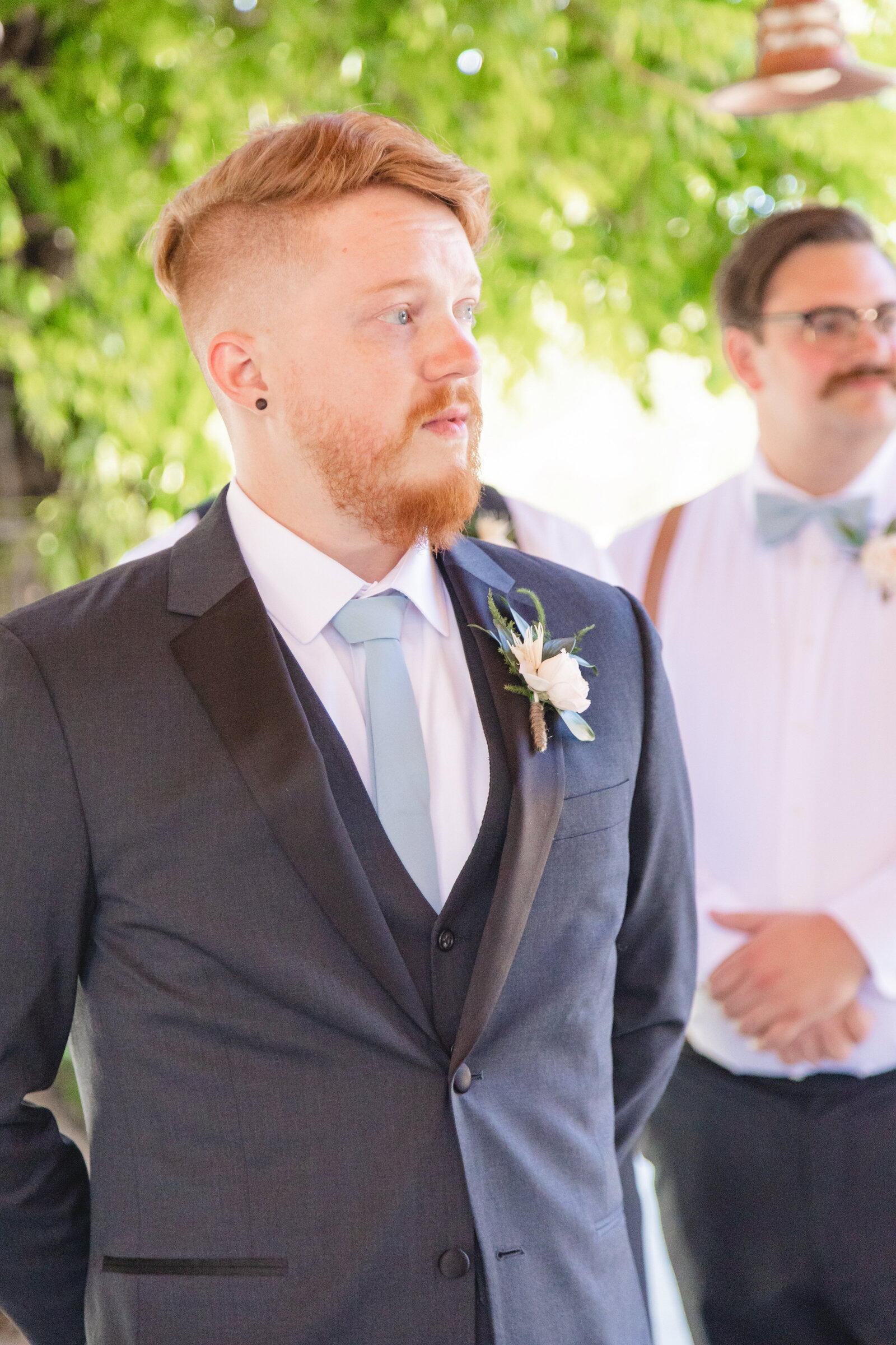groom in black suit crying when he sees his bride