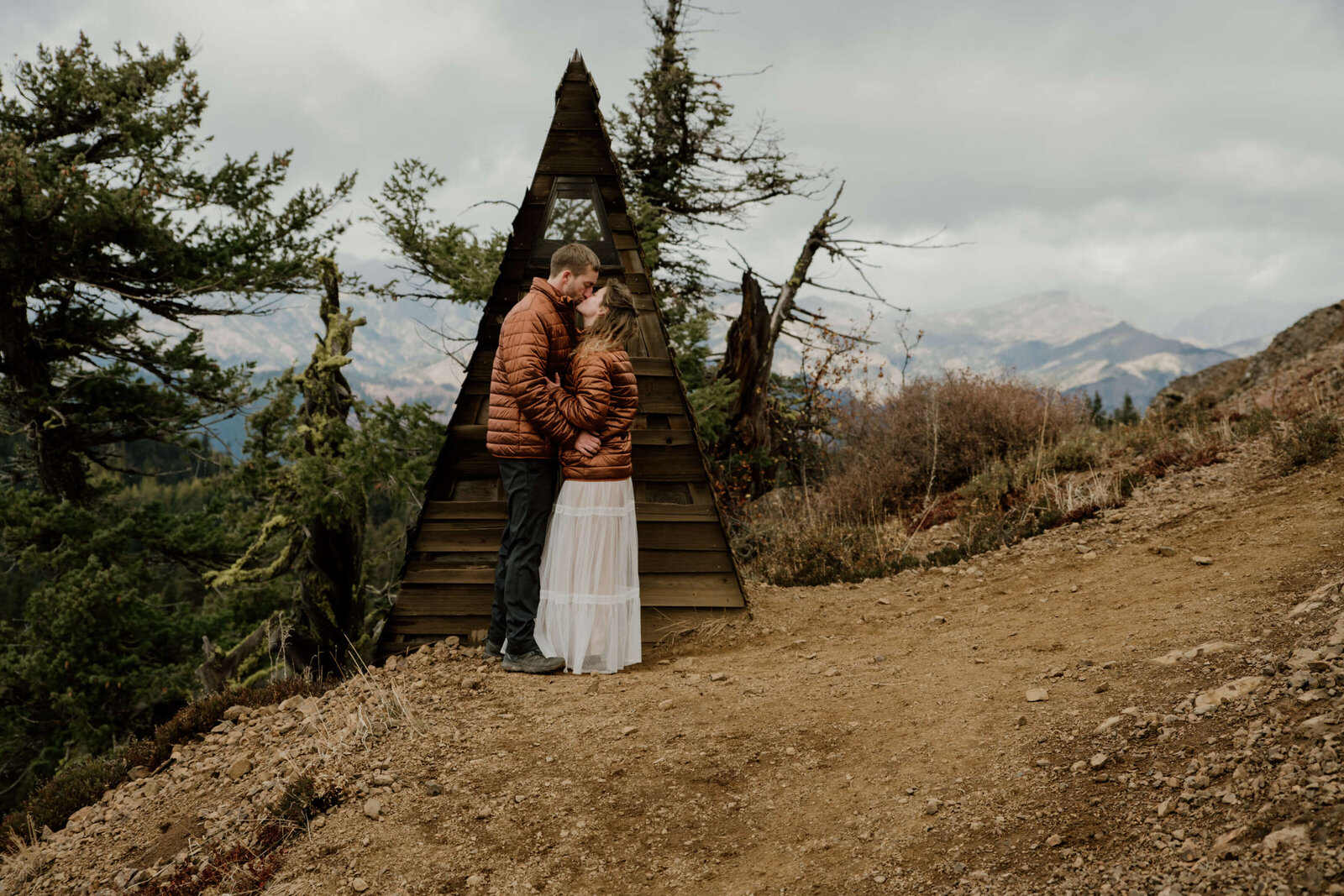 Bride and Groom embracing near a-frame building.