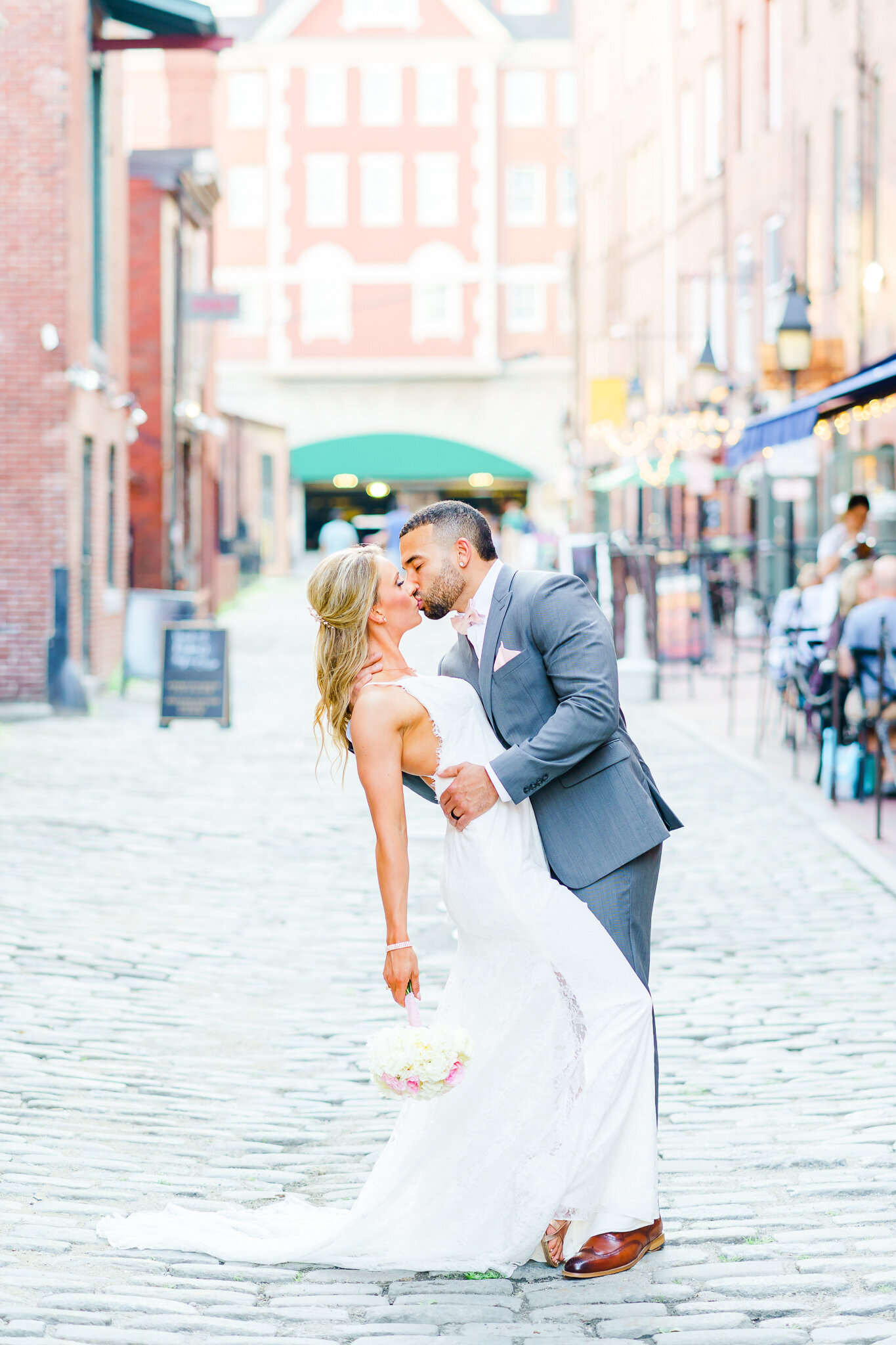 Wedding couple kissing in busy New Hampshire street