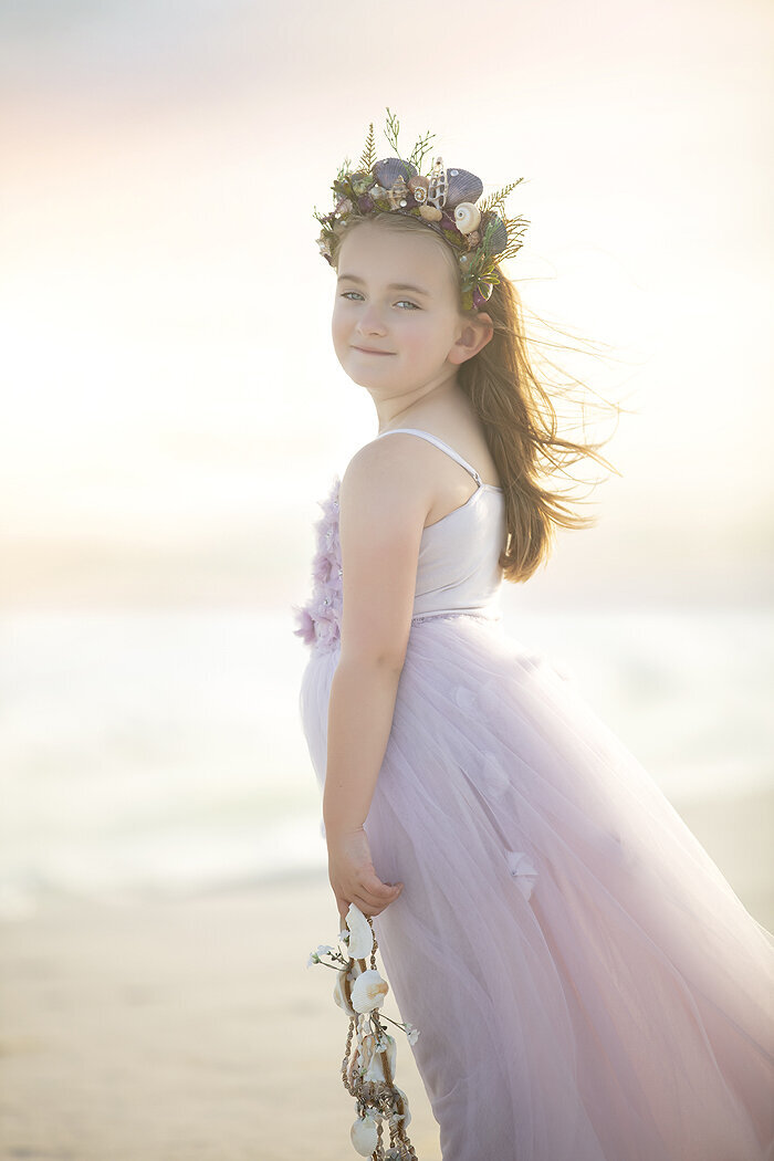 Young girl on the beach wearing a pretty tutu du monde gown.