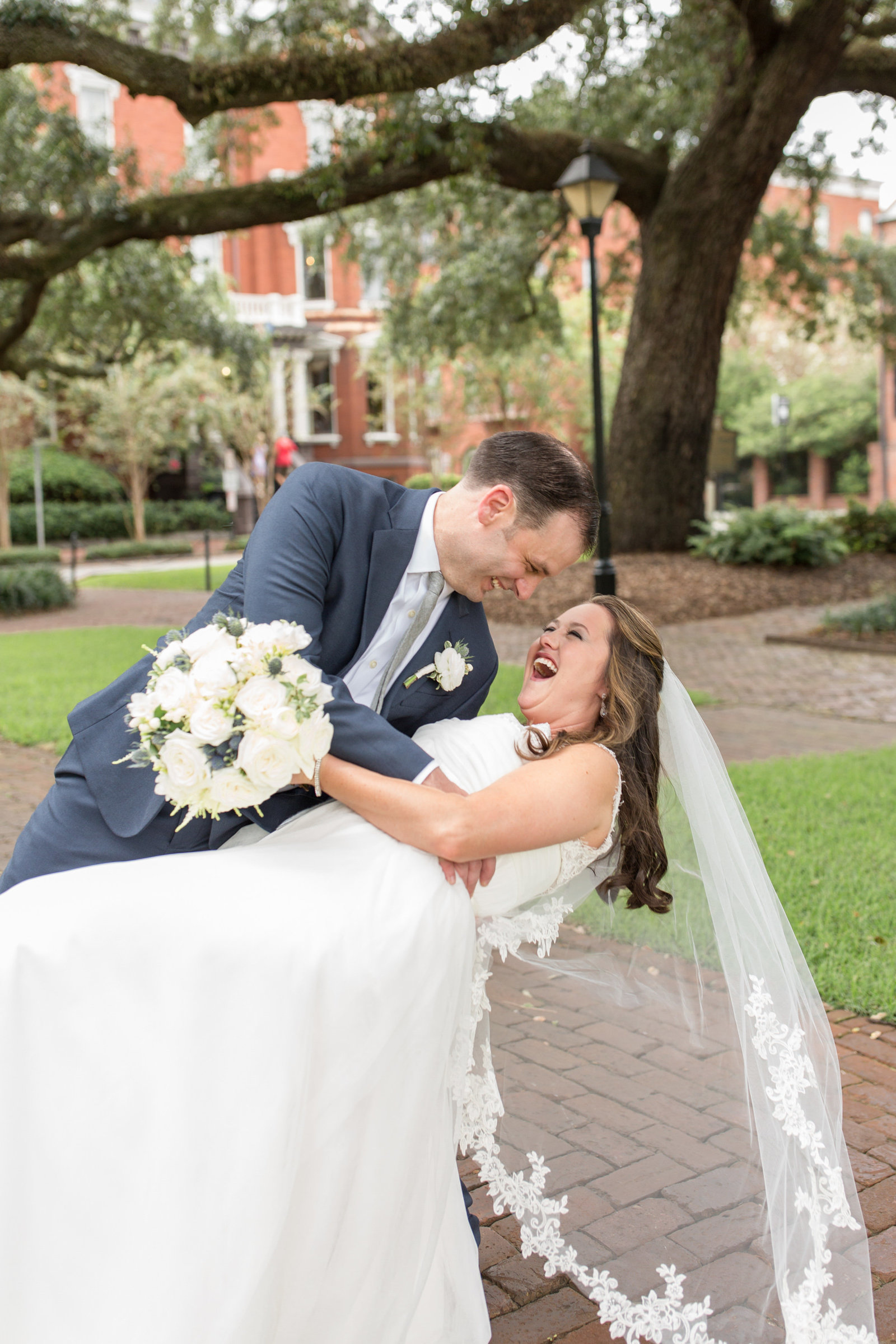 groom dipping bride and she is laughing in front of kehoe house in savannah