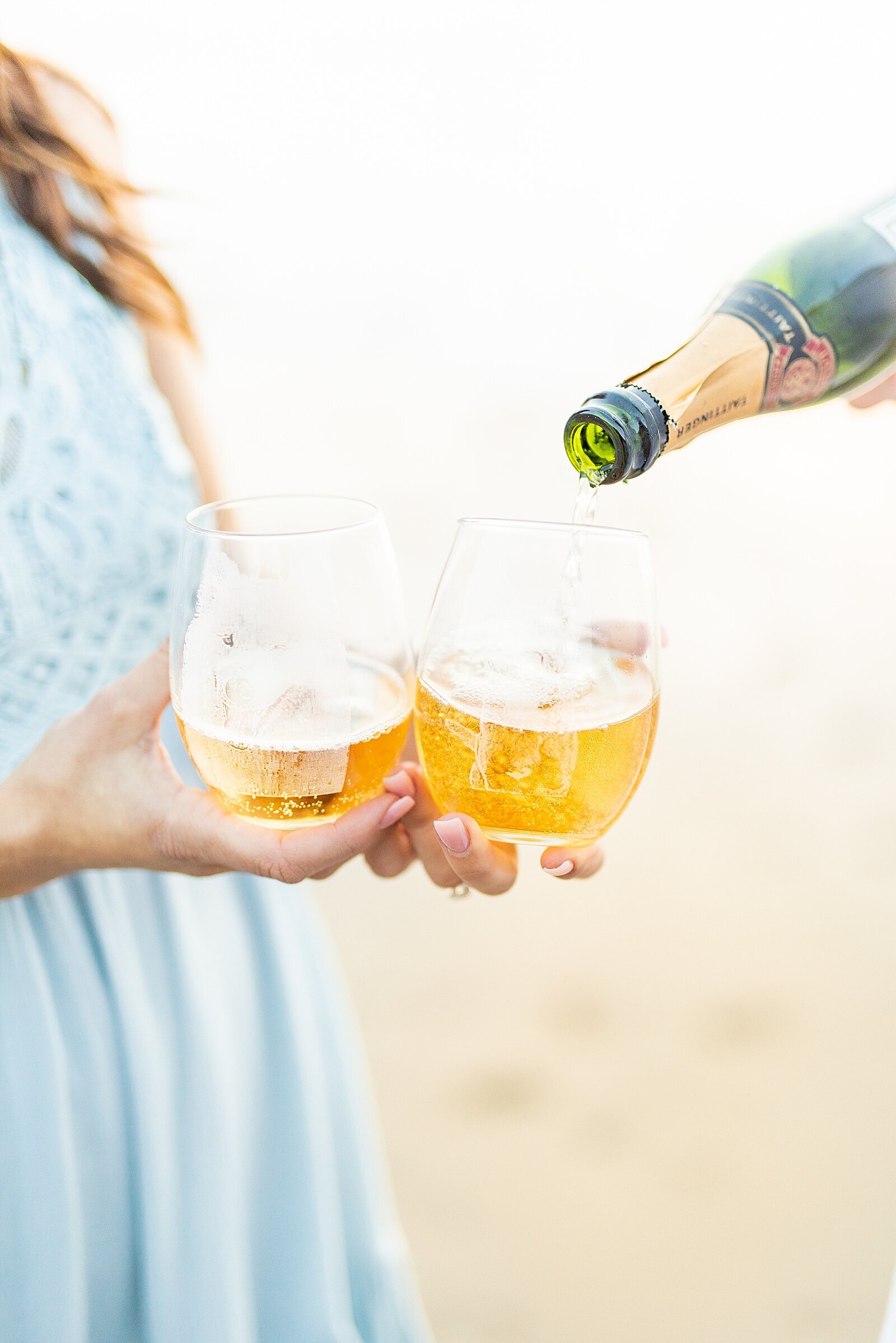 Couple pouring champagne at San Onofre beach in San Clemente, California.