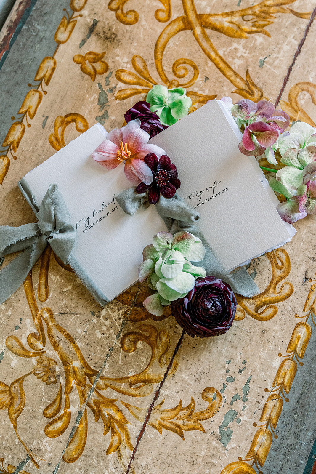 Editorial flatlay of groom’s boutonniere and ring box on golden velvet, styled for a luxury Los Angeles wedding.