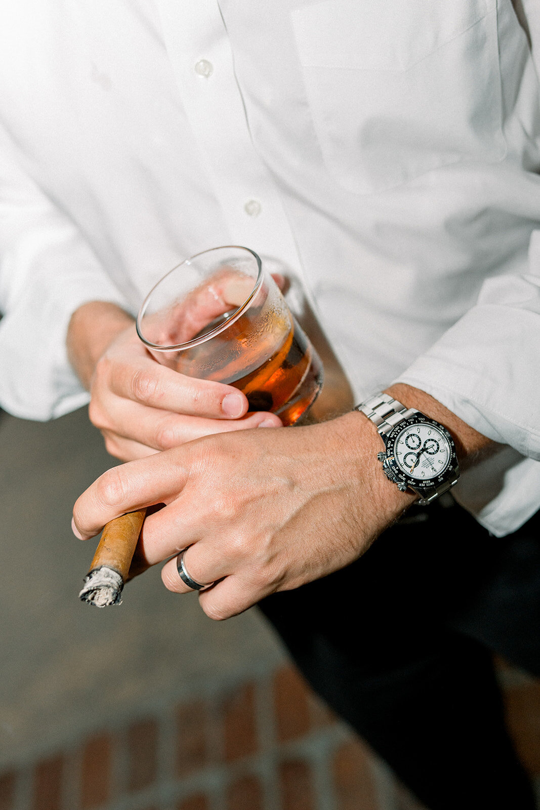Close-up of groom adjusting his watch in a relaxed, editorial moment before the wedding in Los Angeles, CA.