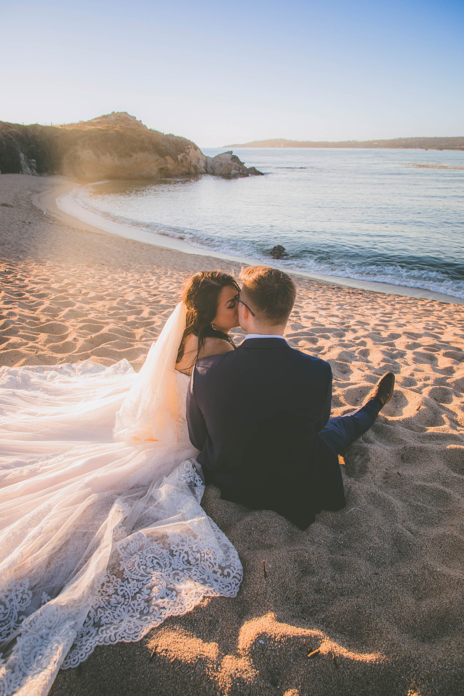 A newlywed couple kisses at sunset during their Monastery Beach small wedding.