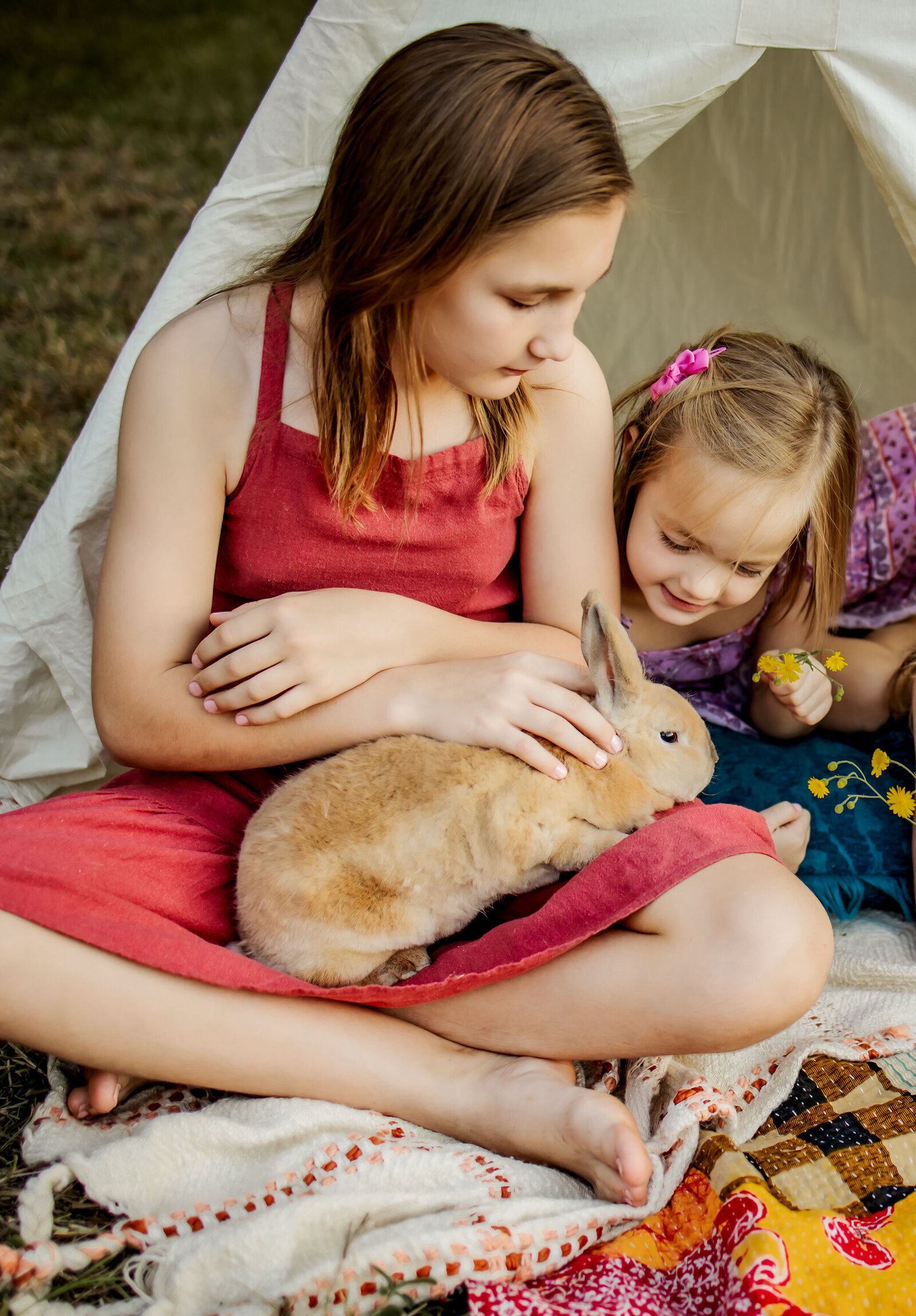 girls playing with a bunny at an outdoor photography session