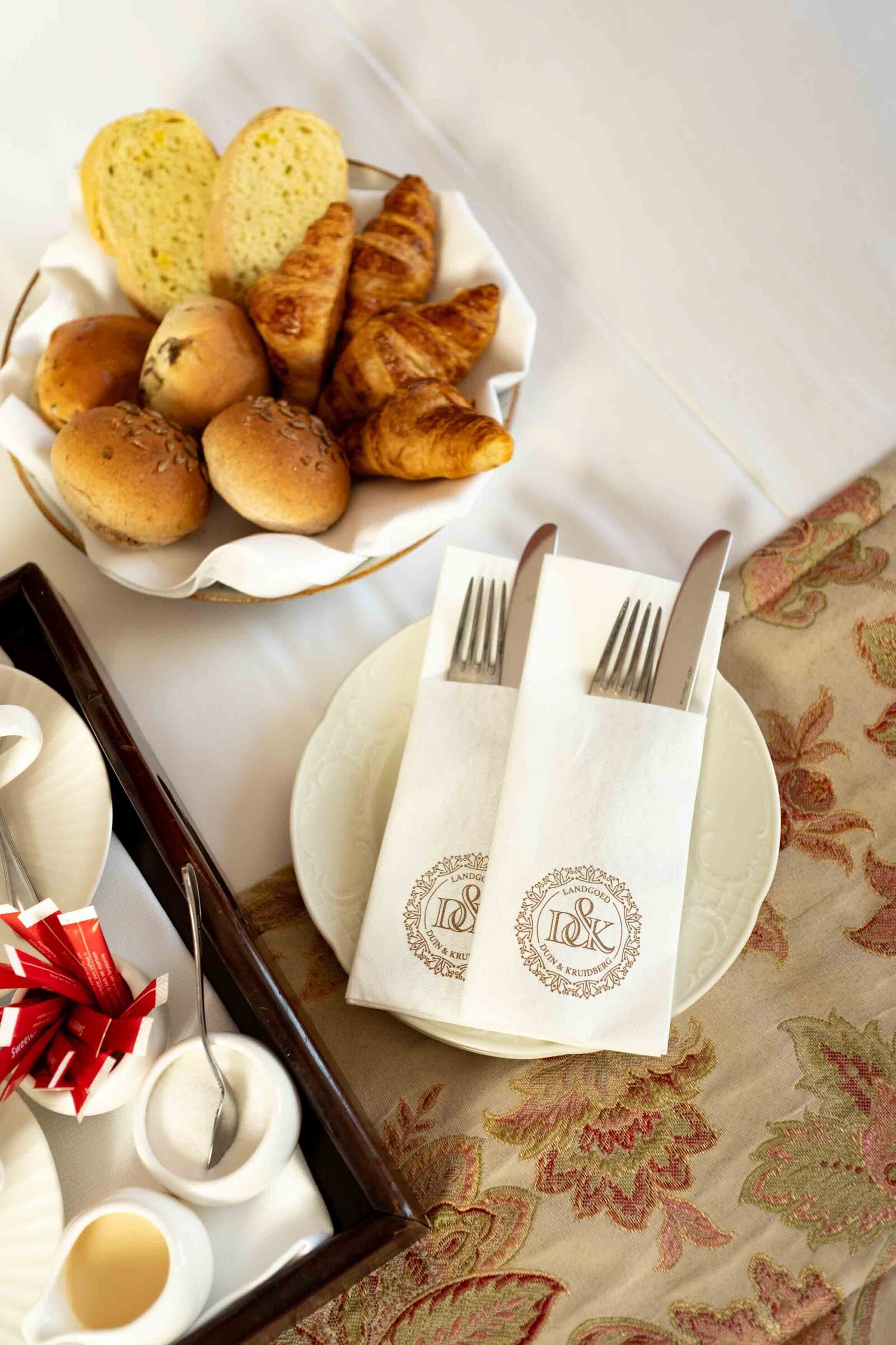 detailshot van servetten met logo van hotel tijdens ontbijt op bed