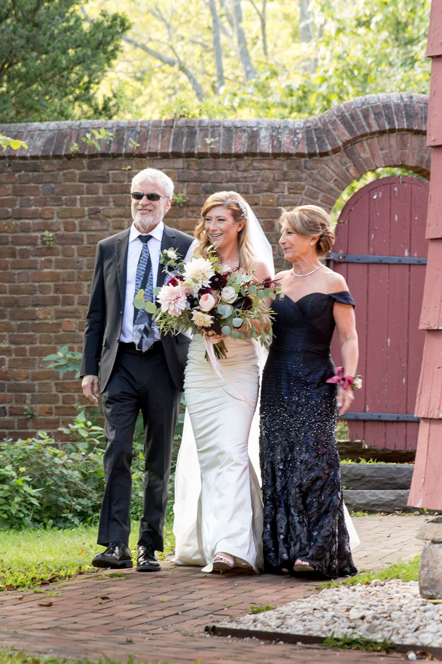 bride and parents walking down the aisle at George Weir Barn