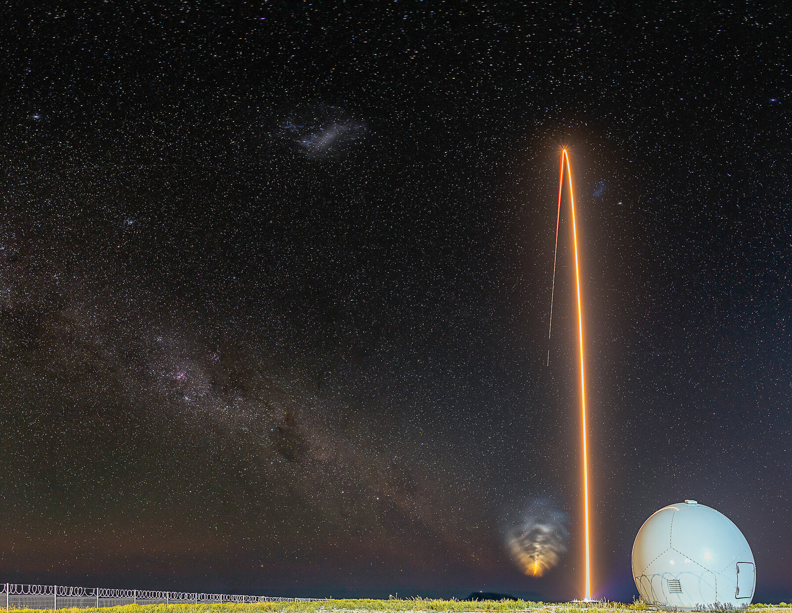 Rocket Lab's Electron rocket launch. Streak long exposure with starry sky background. Radar dome in foreground.
