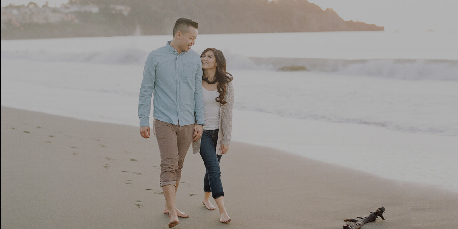 Newly engaged man and his fiancee share a walk together at Baker Beach.