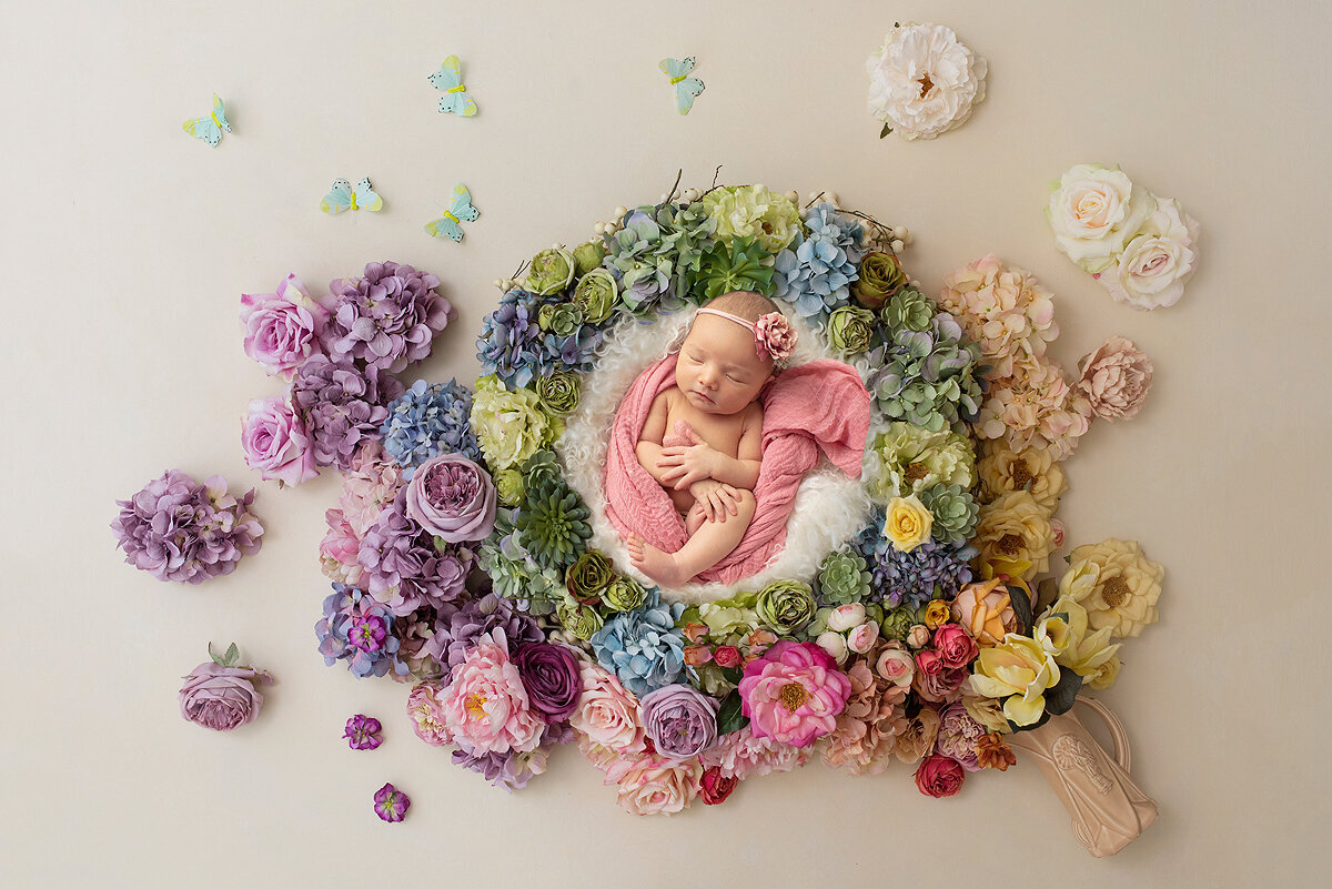 Newborn girl surrounded by florals.