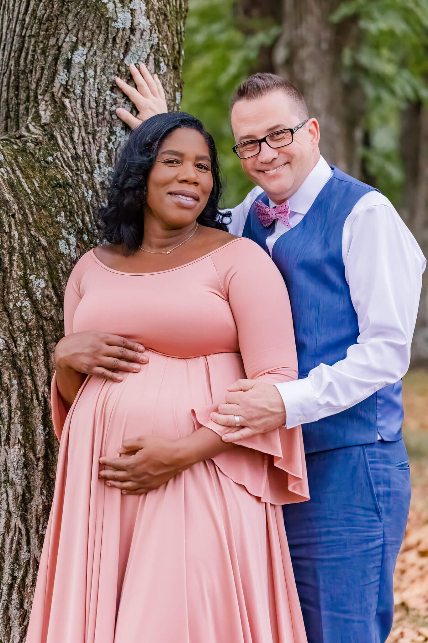 A pregnant couple posing for their maternity portraits.