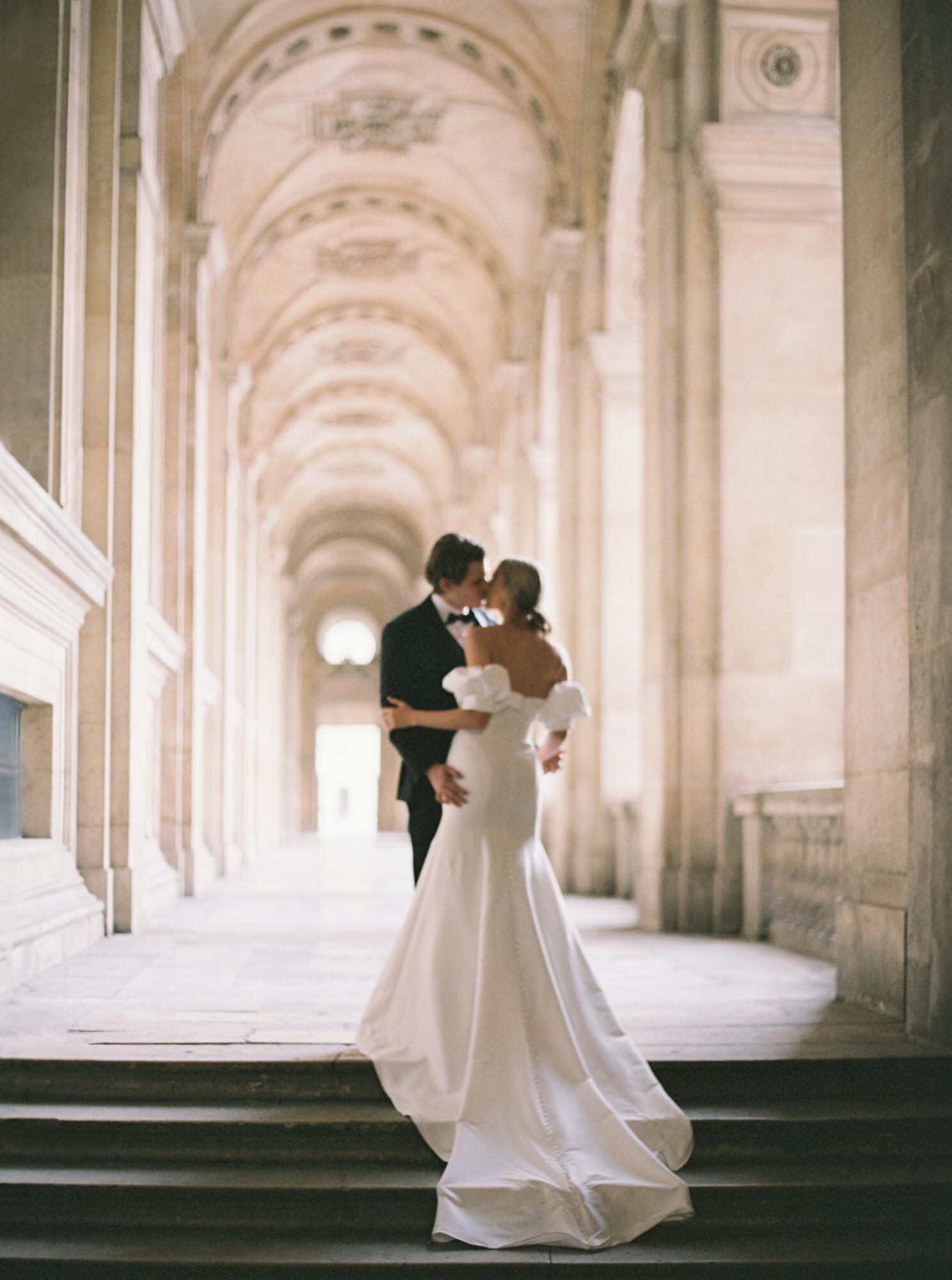 Bride and groom kissing at the Louvre
