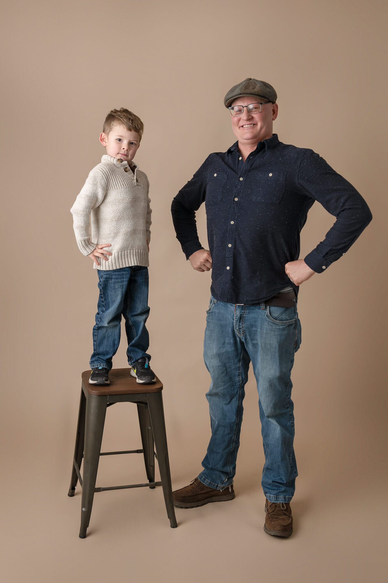 portrait of little boy and his dad in superhero pose