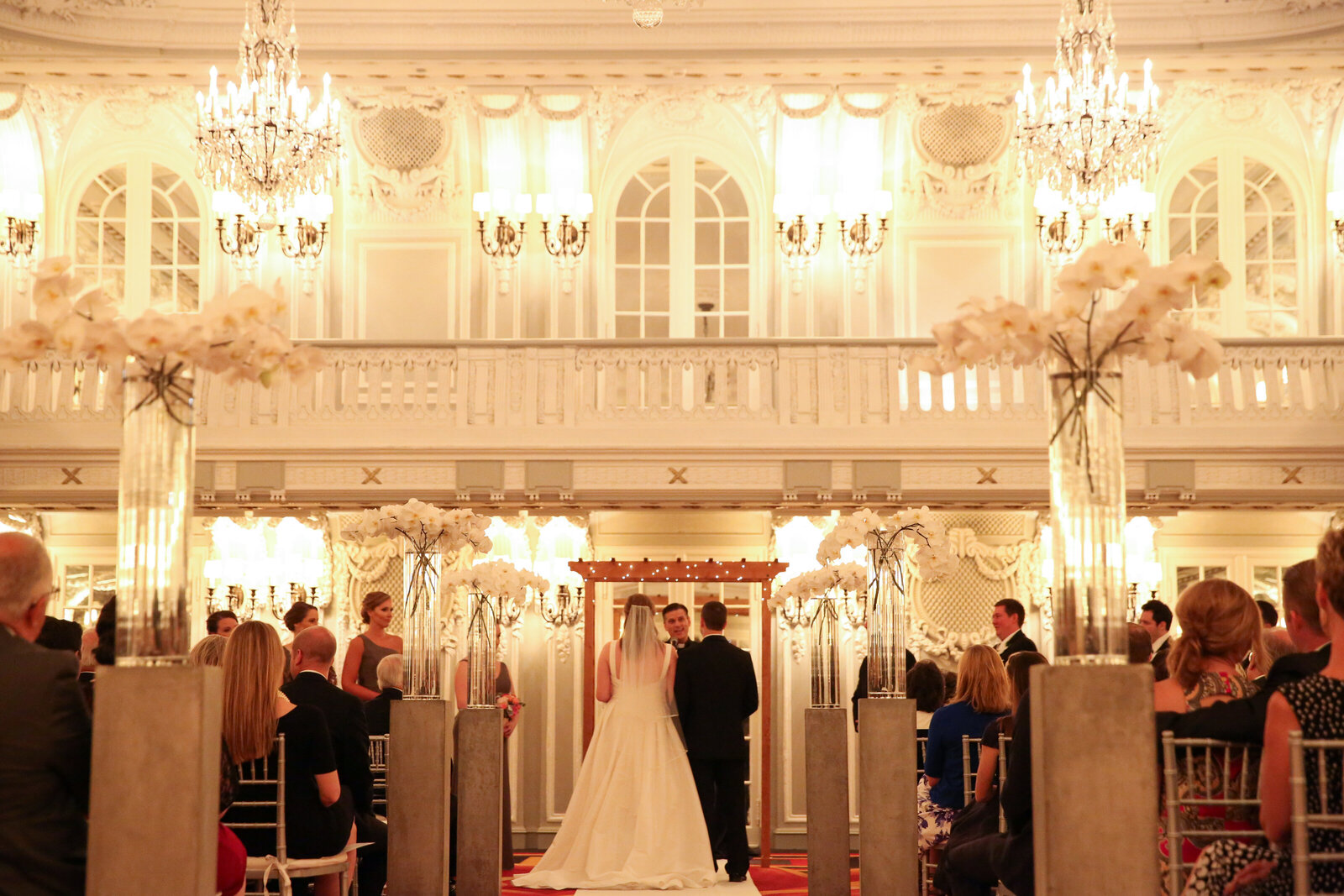 Bride and groom take their vows in grand ballroom