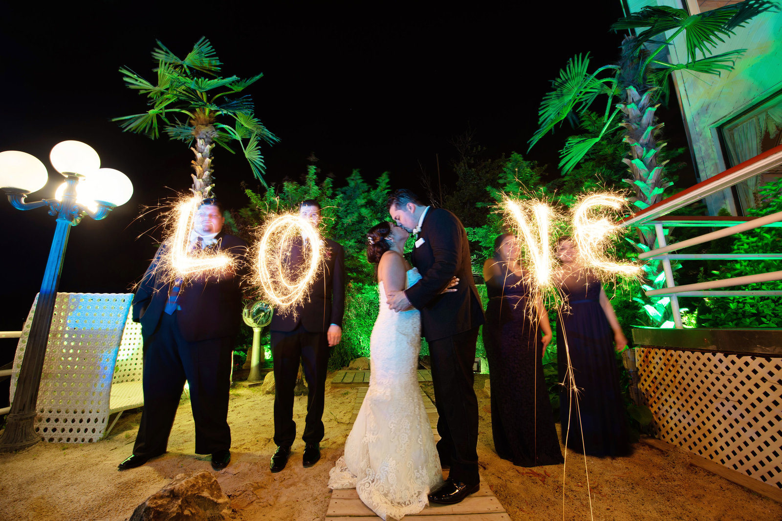 Bride and groom kissing with love in lights at Chateau La Mer