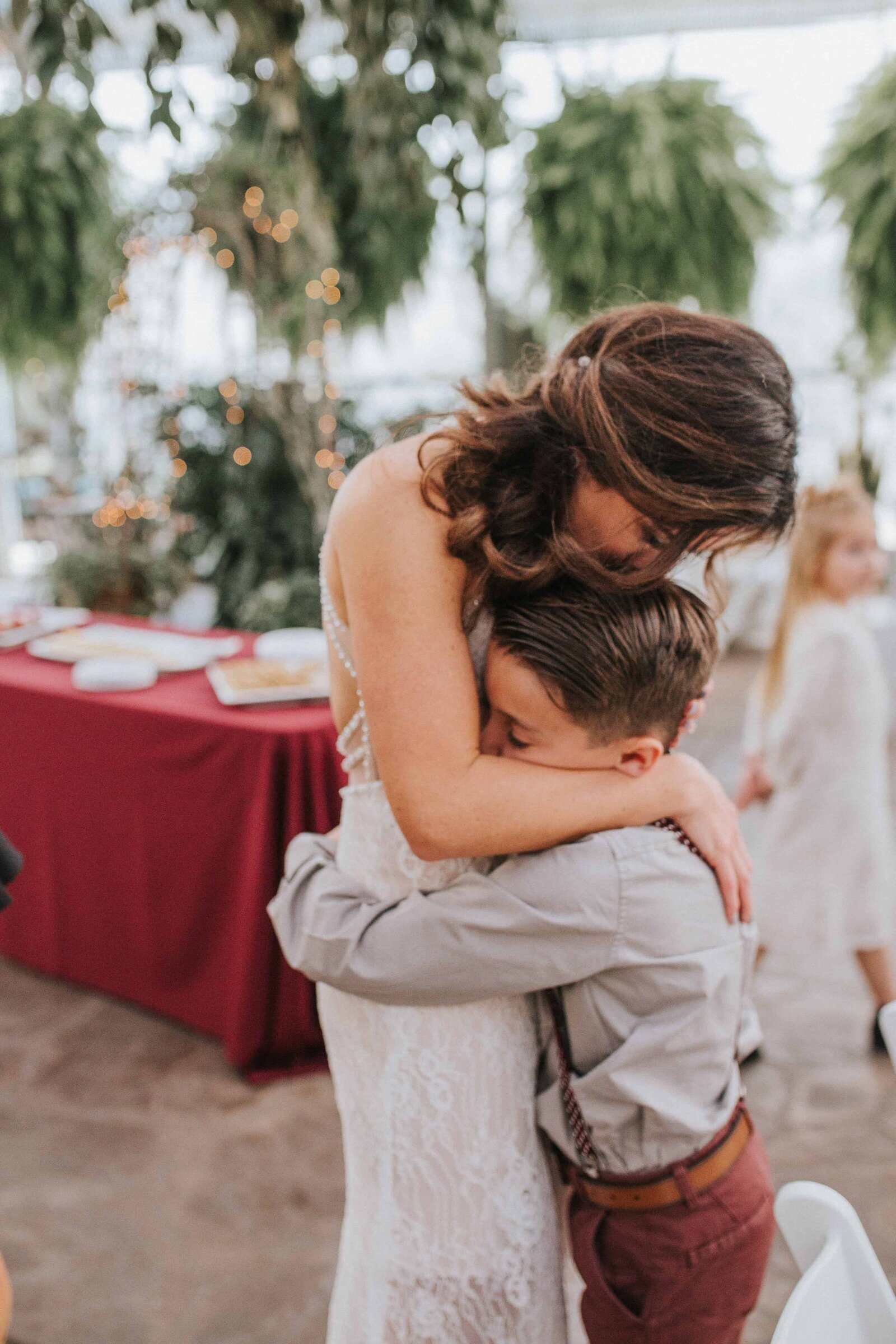 Sacramento Wedding Photographer captures bride hugging son while wearing wedding attire