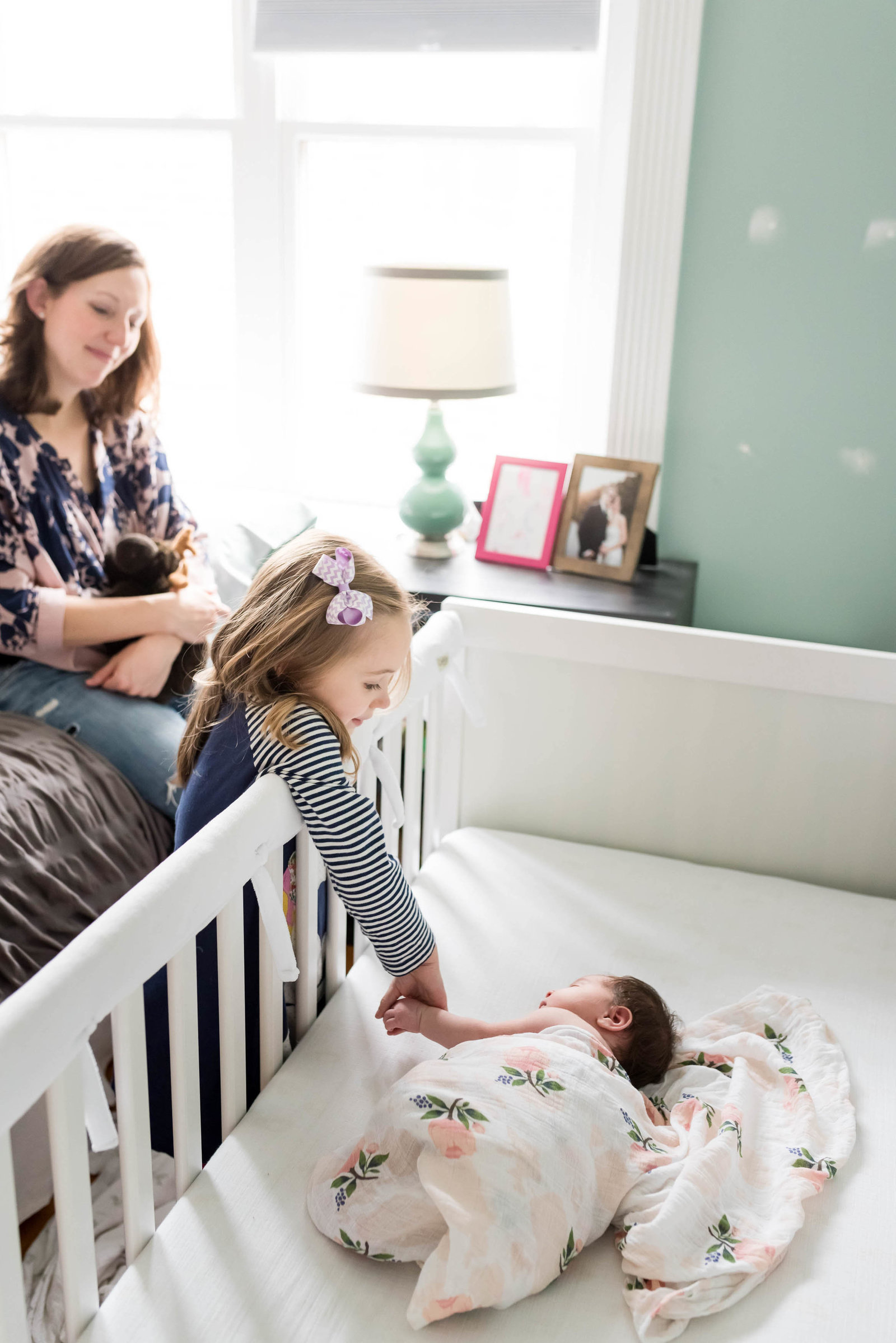 Newborn posed at home on furniture in lifestyle session Boston with sister
