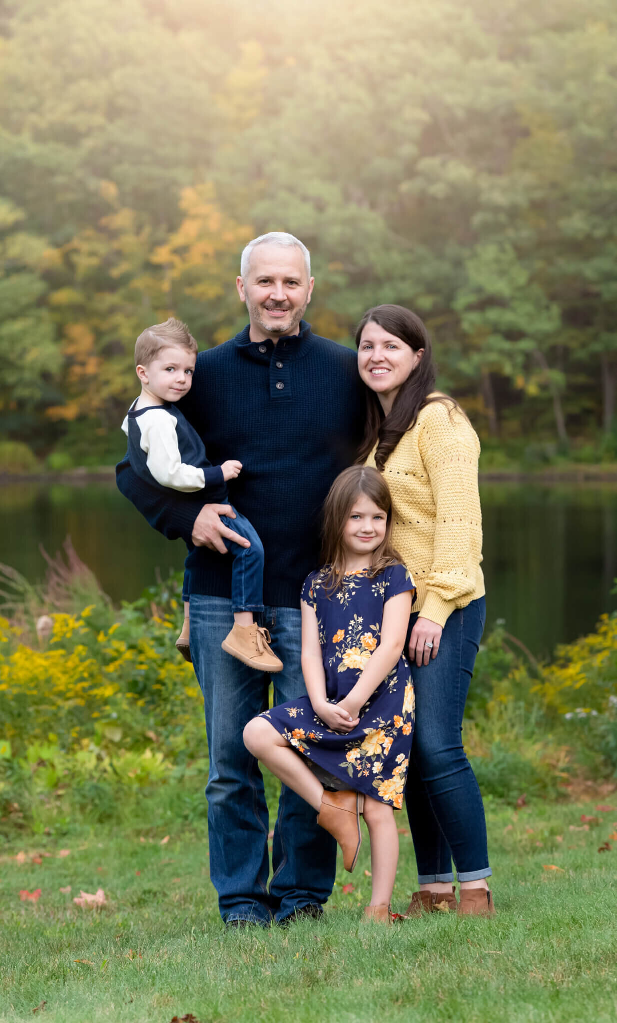 Boston family wearing navy tans and yellows for fall photos in front of water