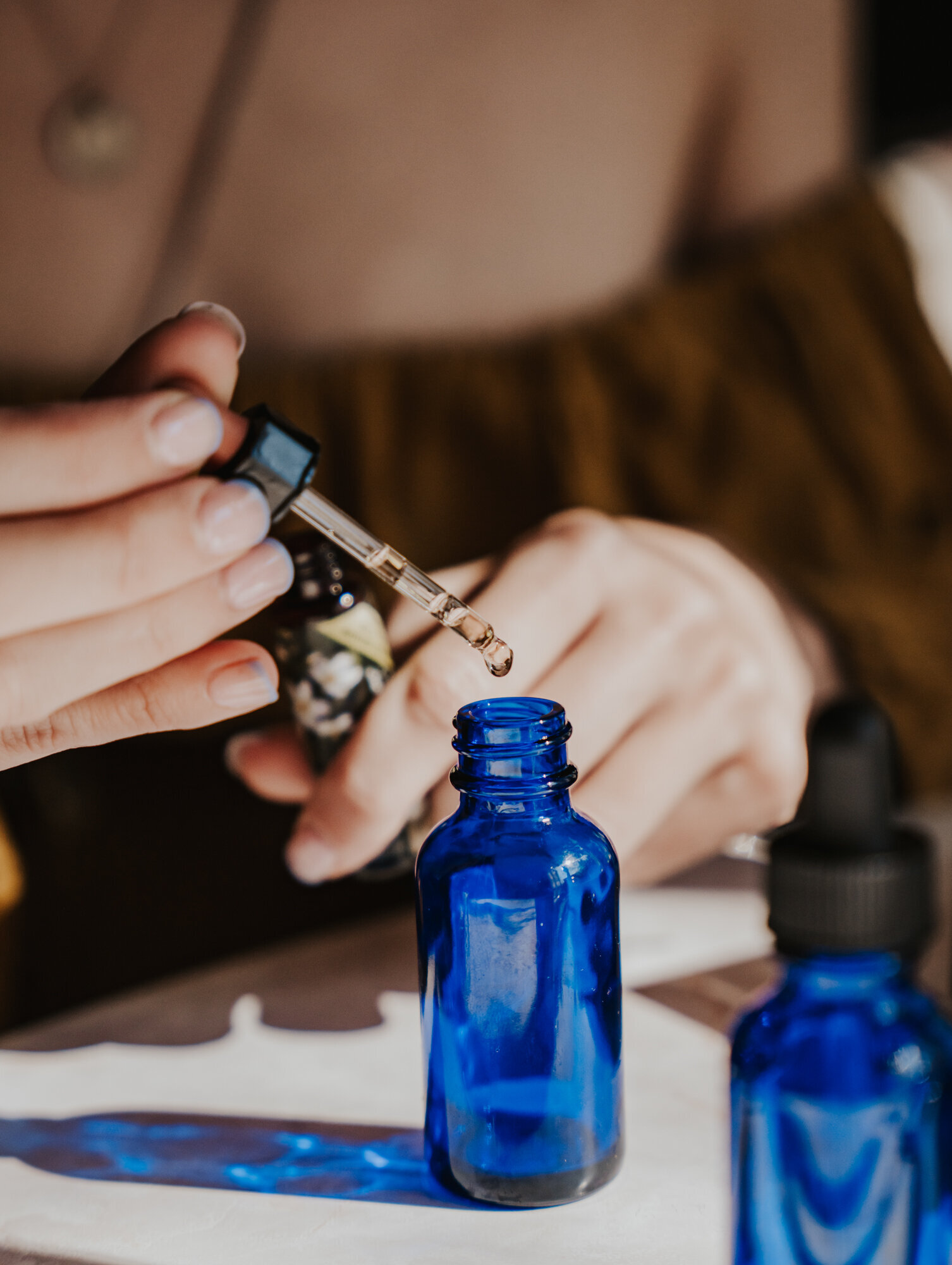 Branding Photographer,  a woman drops oils into a small bottle