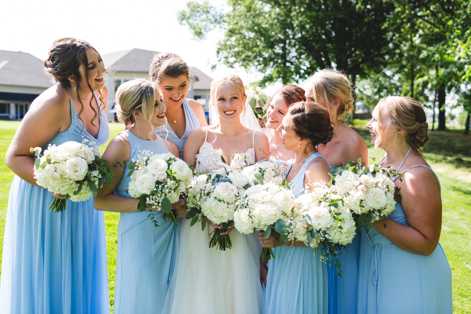 bridal party smiling and laughing in blue with white flowers ohio wedding