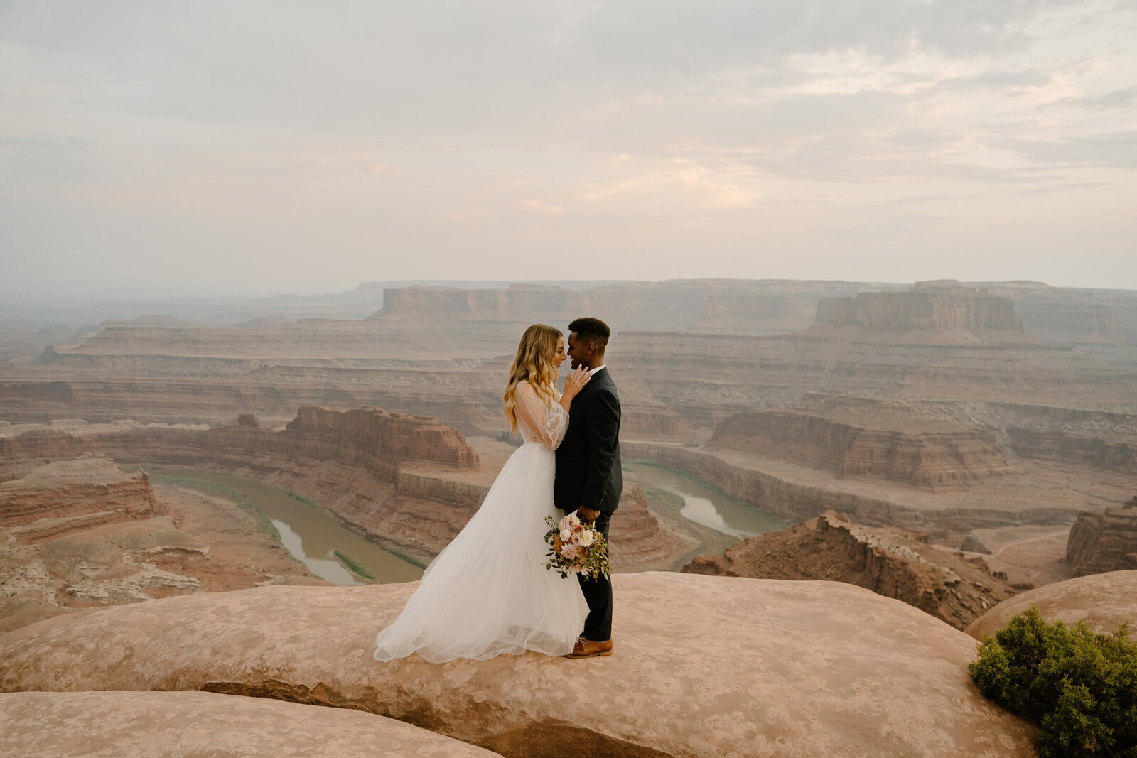 Sunset wedding at Dead Horse State Park in Moab, Utah of a beautiful mixed couple