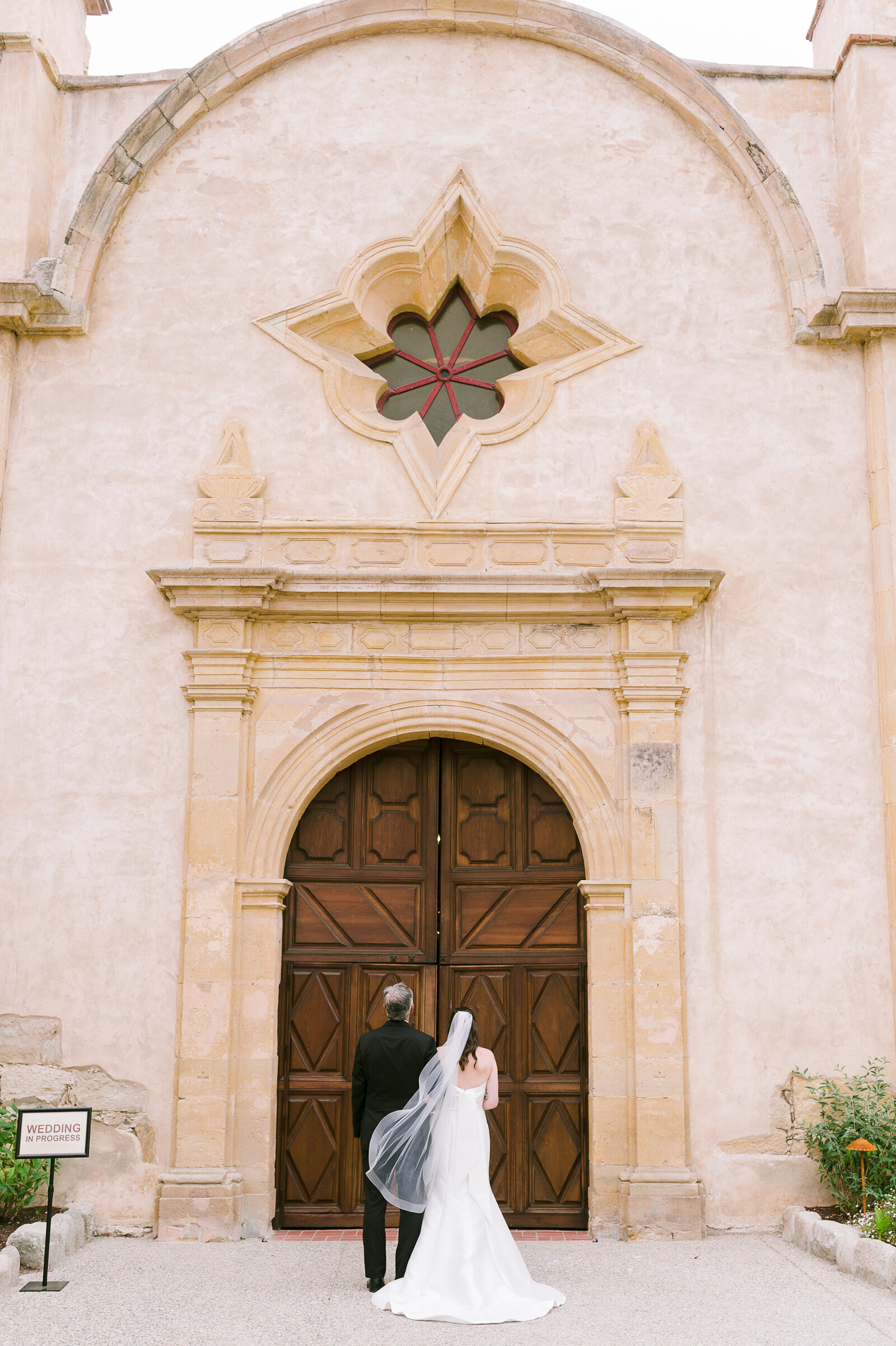 Bride and her father waiting to walk down aisle at Carmel Mission