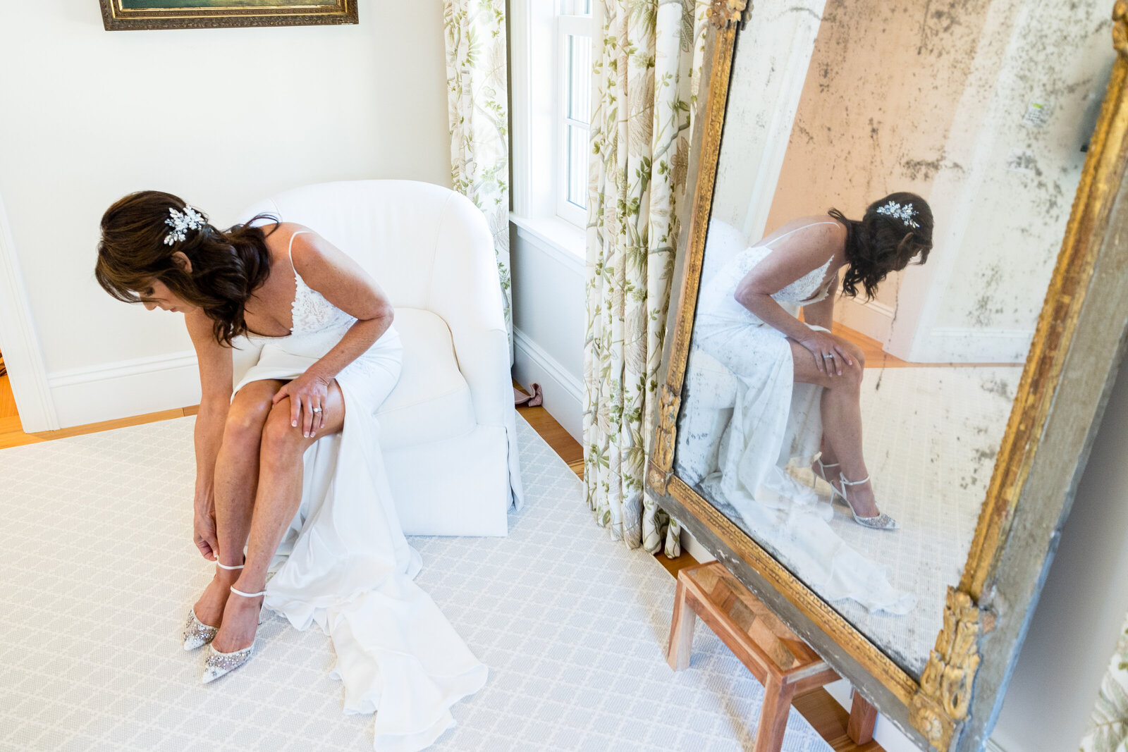 reflection of bride putting on shoes