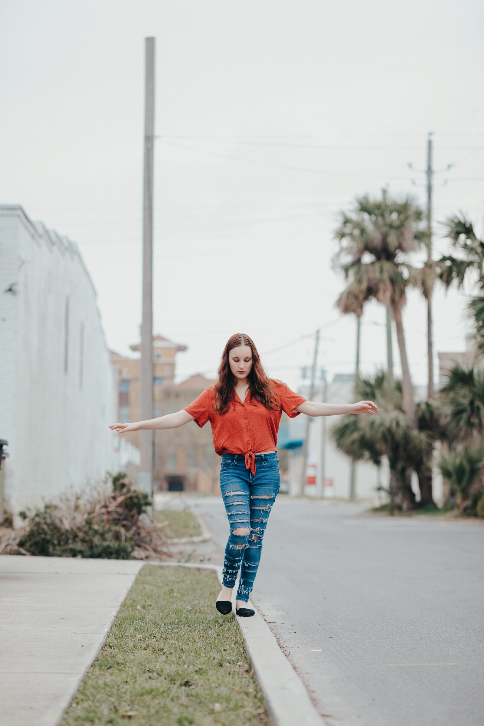 Downtown Pensacola  senior pictures girl posing  on sidewalk
