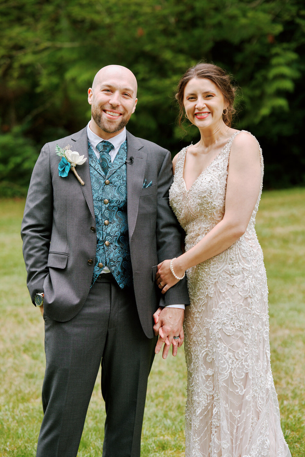 Bride and groom hold hands and smile for a wedding day portrait