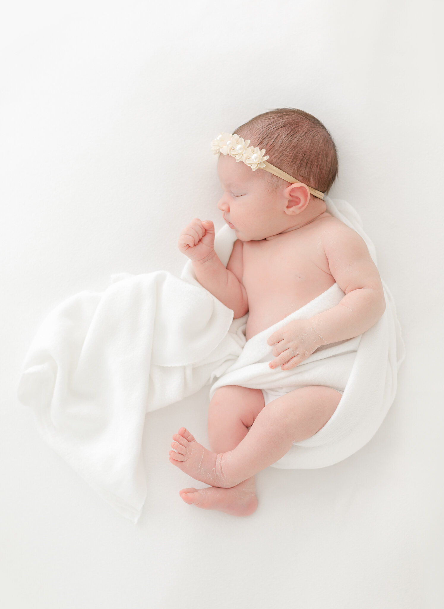 sleeping newborn baby girl wearing headband during massachusetts newborn photography session