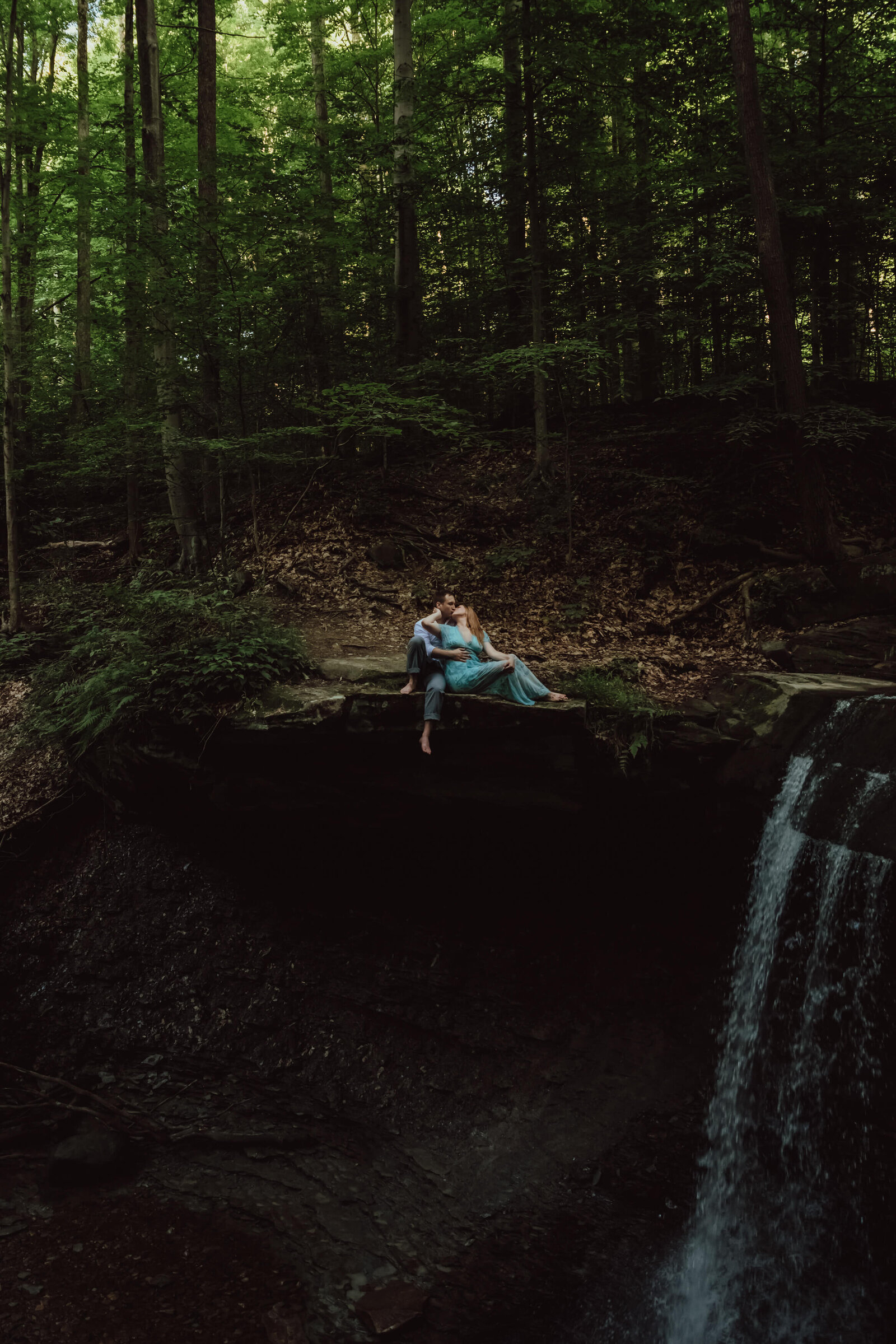 Couple sit at edge of waterfall for engagment photos in Clevleand.