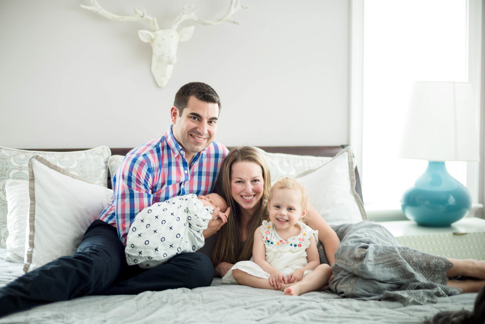 parents hugging newborn at home lifestyle session Family photo