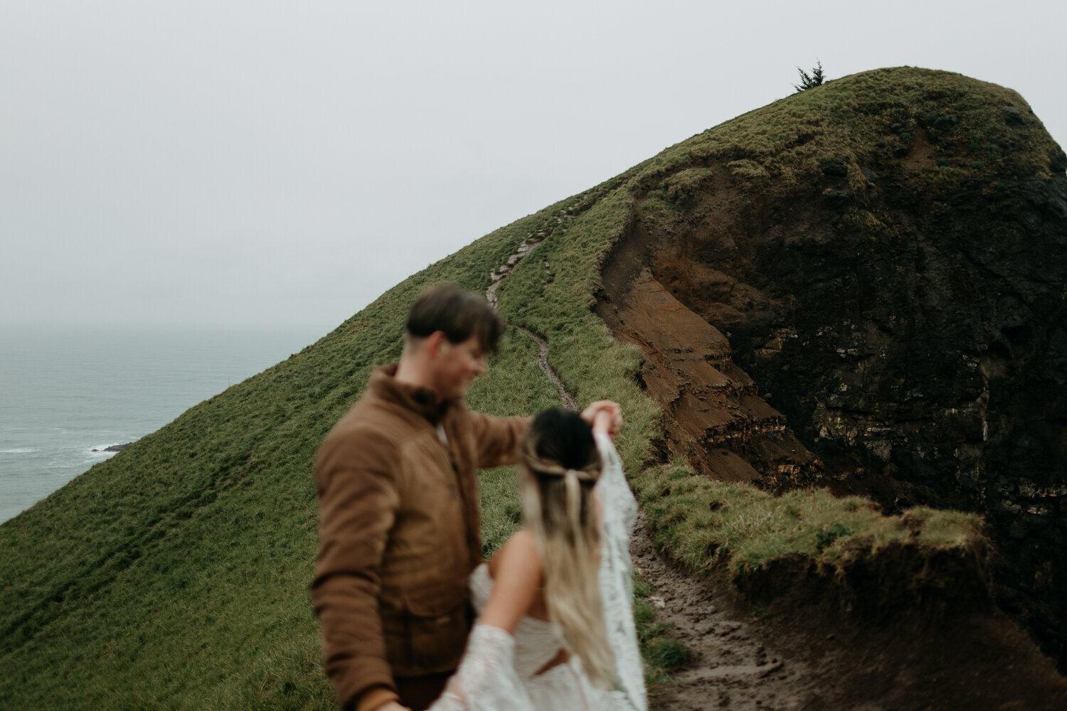 Boho elopement wedding couple in the rain at God's Thumb grassy knoll at the Oregon Coast