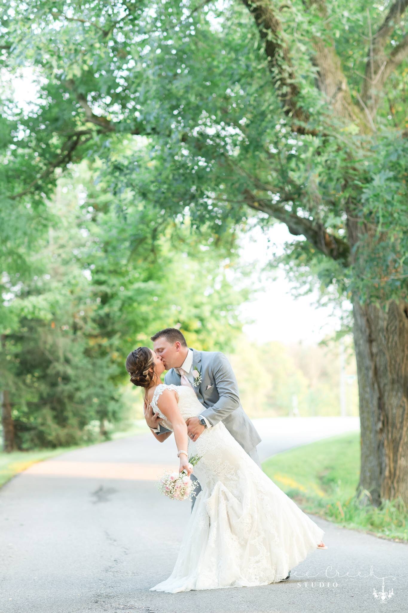bride & groom kissing in road