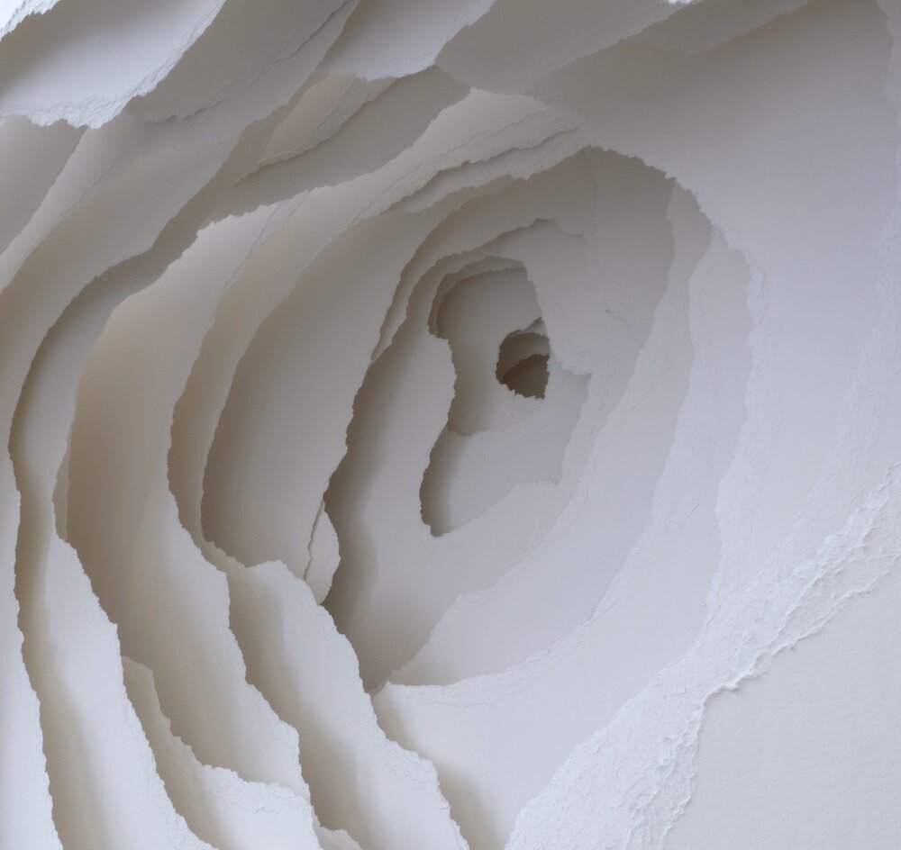 Bright-white paper torn into layers of holes diminishing in size. Art by Angela Glajcar.