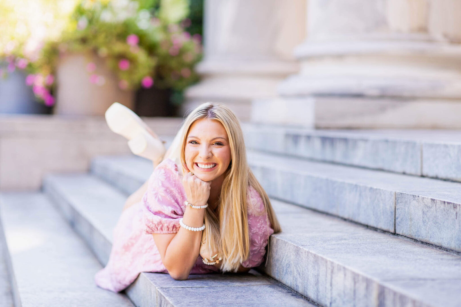 Senior in pink dress on marble stairs of Sanford university