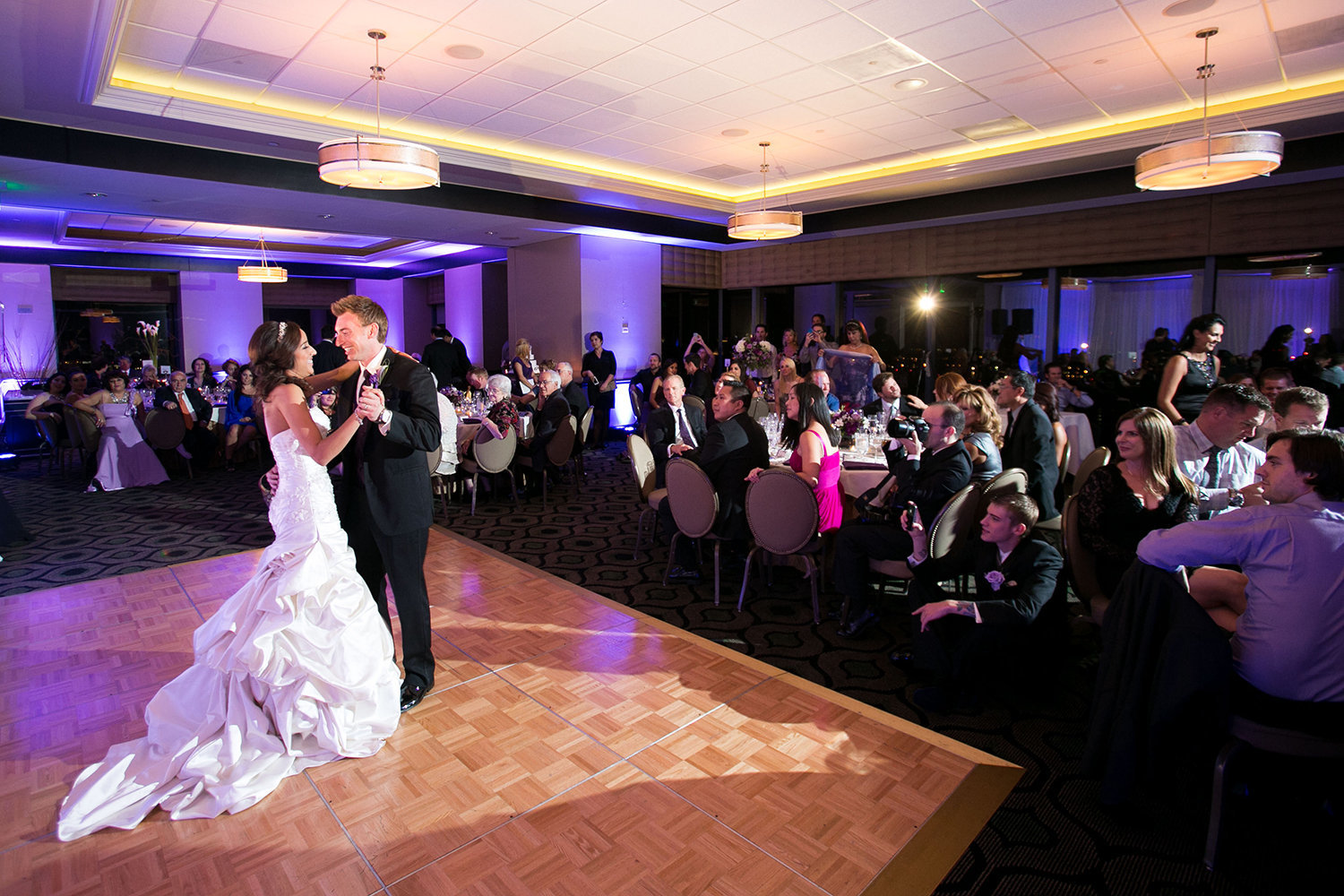 The first dance as a large crowd of wedding guests watch at the University Club on Symphony Tower | Reception Uplighting