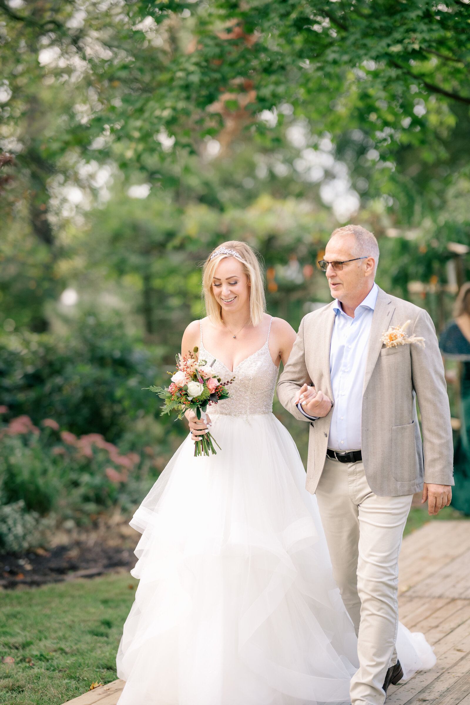 Bride Pascalle is accompanied up the aisle by her father on her September wedding day