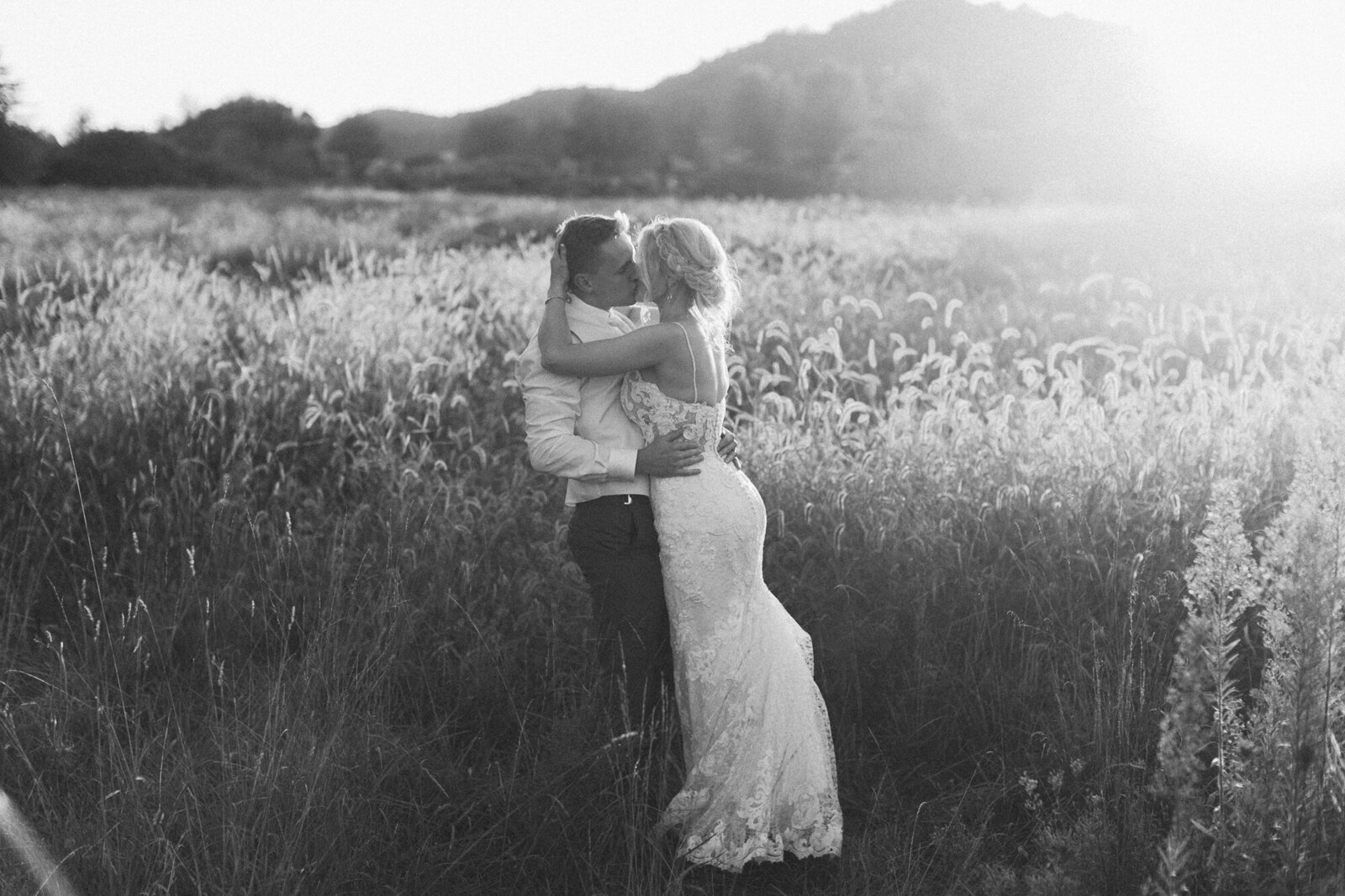 bride and groom in a sunlit field away  in the last bit of daylight