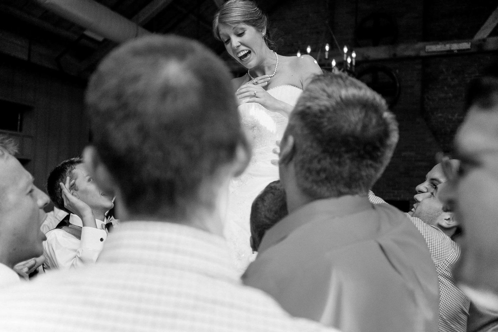 Bride is lifted by guests at reception, Cork Factory Hotel, Lancaster, Pennsylvania