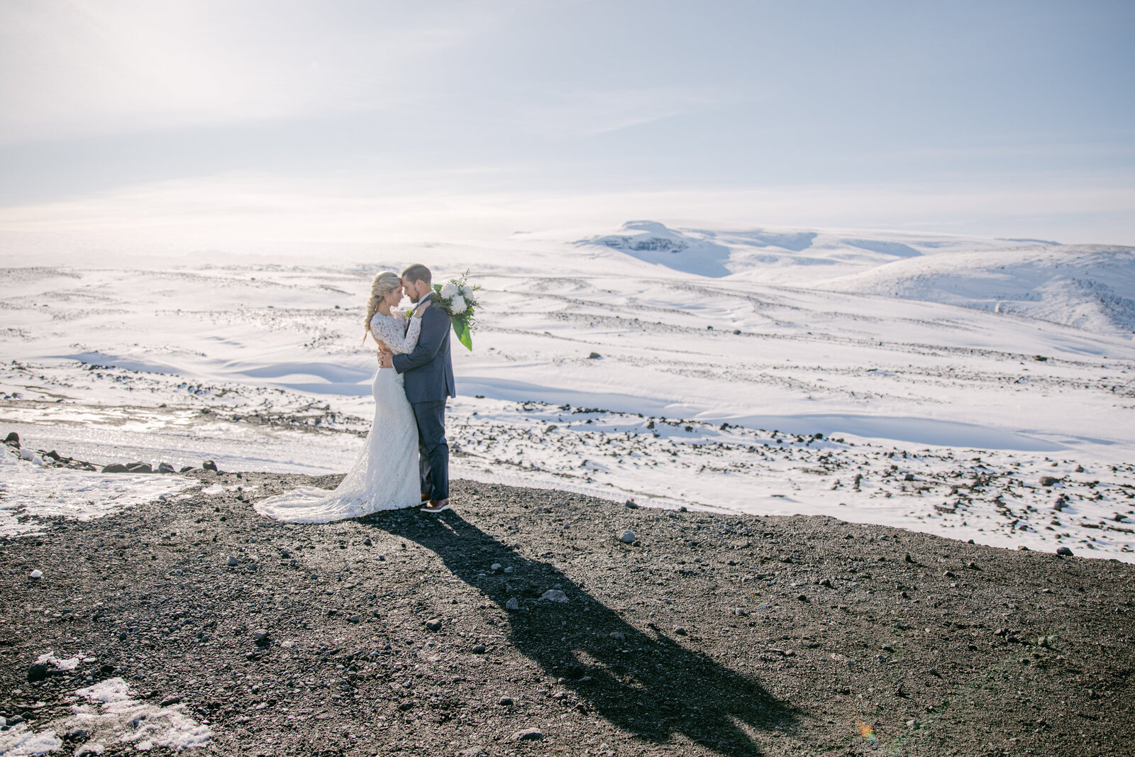 bride and groom face each other in iceland terrain