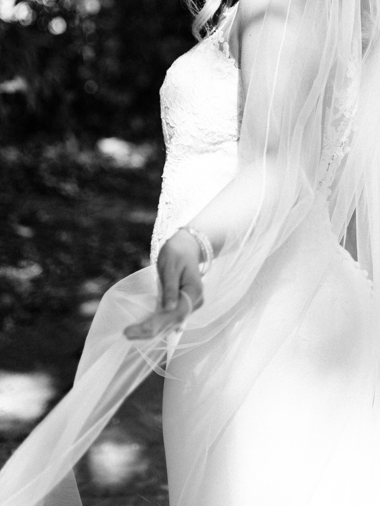 An artistic, film-inspired image taken by San Antonio wedding photographer KD Captures. A bride is twisting while holding her veil. This image only shows her hand and her veil.