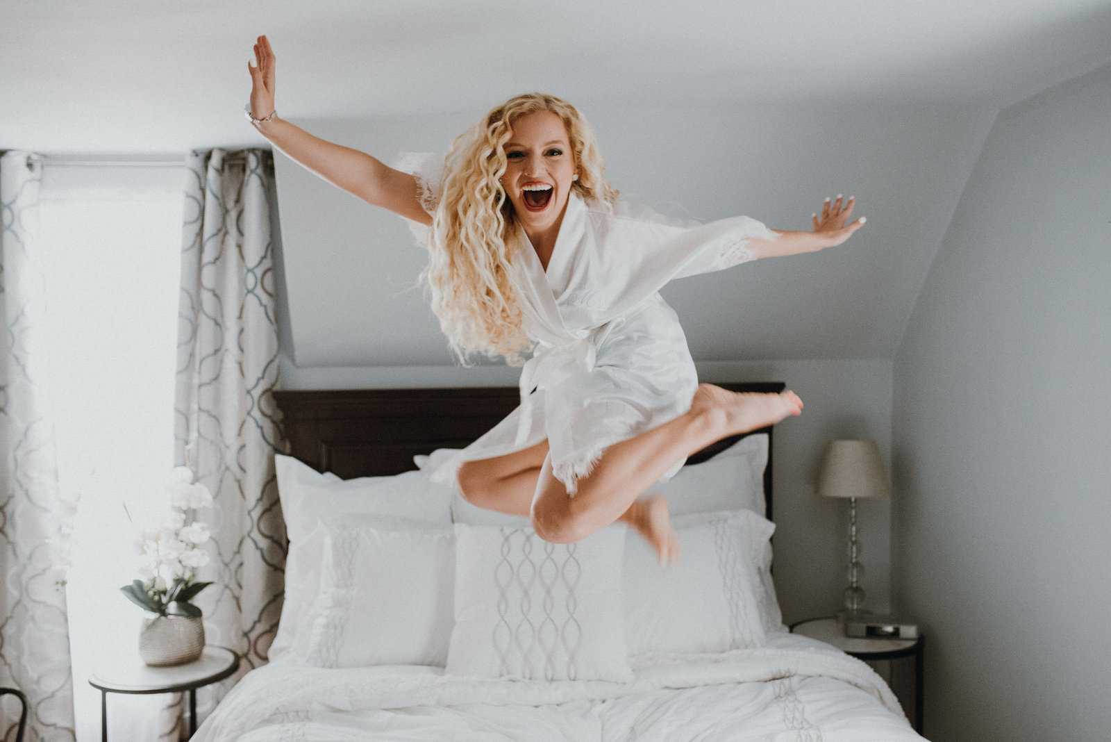 Bride jumping on the bed just before her Bentonville Arkansas Wedding